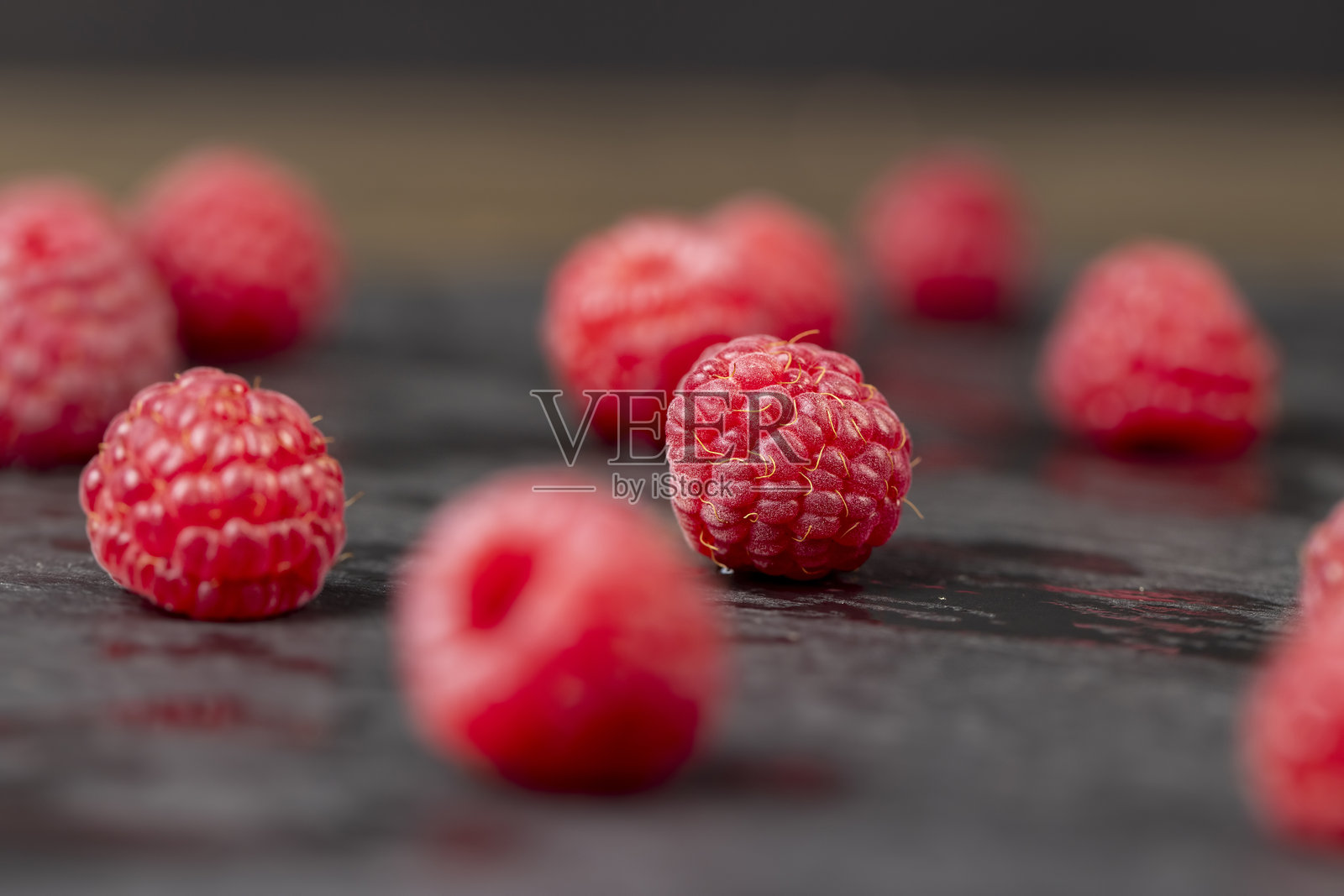桌子上的覆盆子，采摘的成熟覆盆子数量很多，特写红色。照片摄影图片