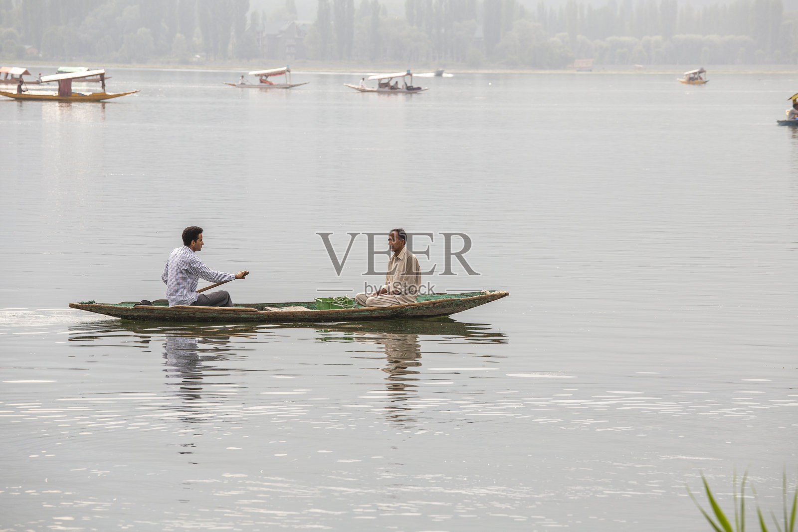 达尔湖的生活方式，当地人使用小船（Shikara）在印度斯利那格的湖泊中进行交通。照片摄影图片