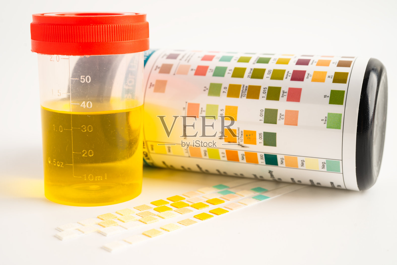 尿液分析，实验室中的尿液杯与试剂条pH纸测试及比较图表。照片摄影图片