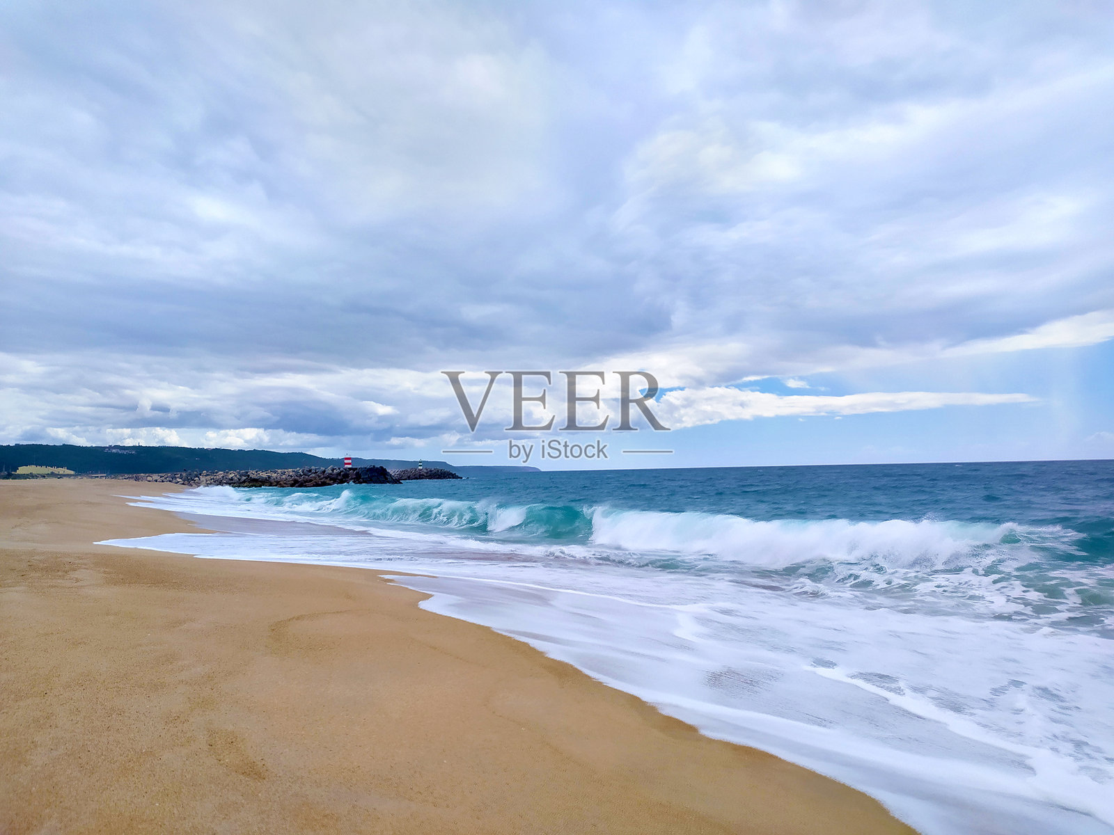 戏剧性的海岸风景，波浪在多云的天空下拍打着沙滩。唤起宁静与力量，适合旅行、自然或励志内容。照片摄影图片