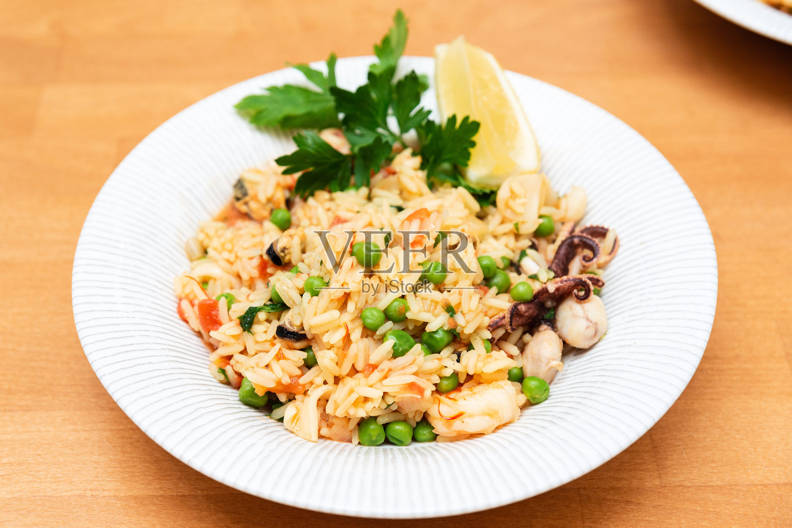 海鲜米饭配豌豆和柠檬装饰。照片摄影图片