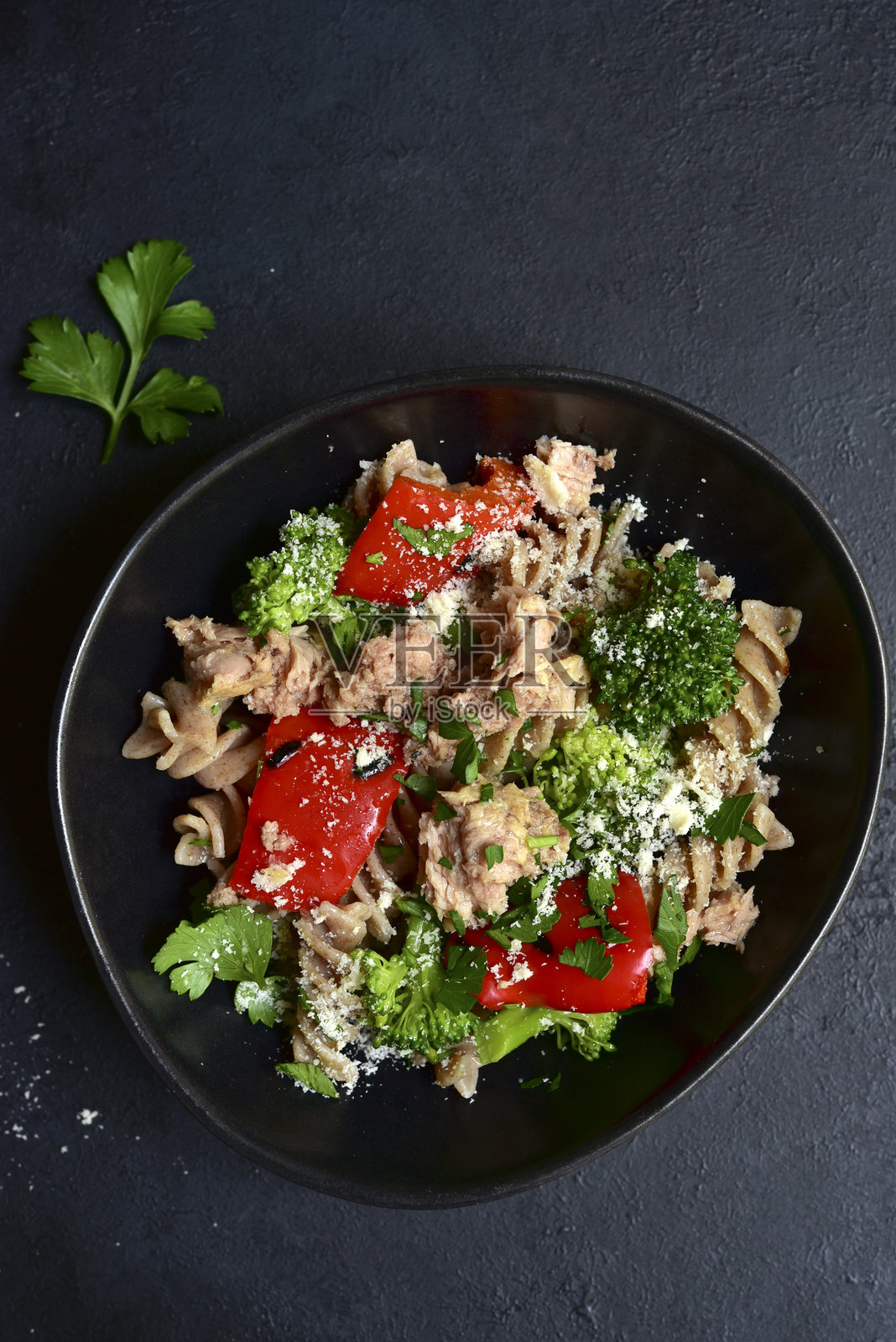 全谷物意大利面沙拉配金枪鱼和蔬菜。俯视图，留有空白空间。照片摄影图片