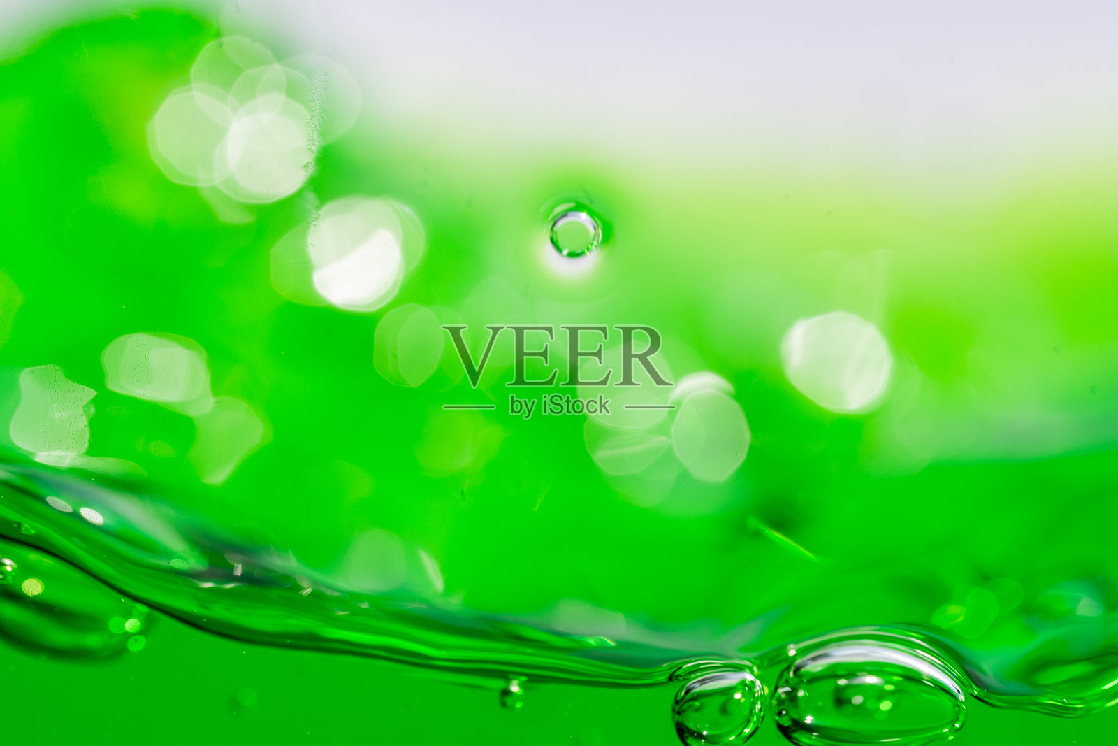 水波，特写生动的绿色液体与气泡，捕捉动态运动和新鲜感。非常适合用作背景、饮料或抽象概念。软饮料照片摄影图片