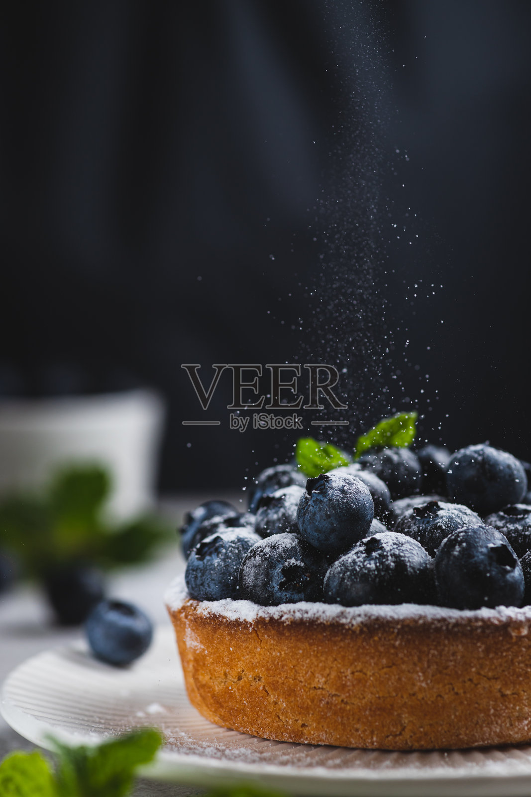 蓝莓派上撒有糖粉。照片摄影图片