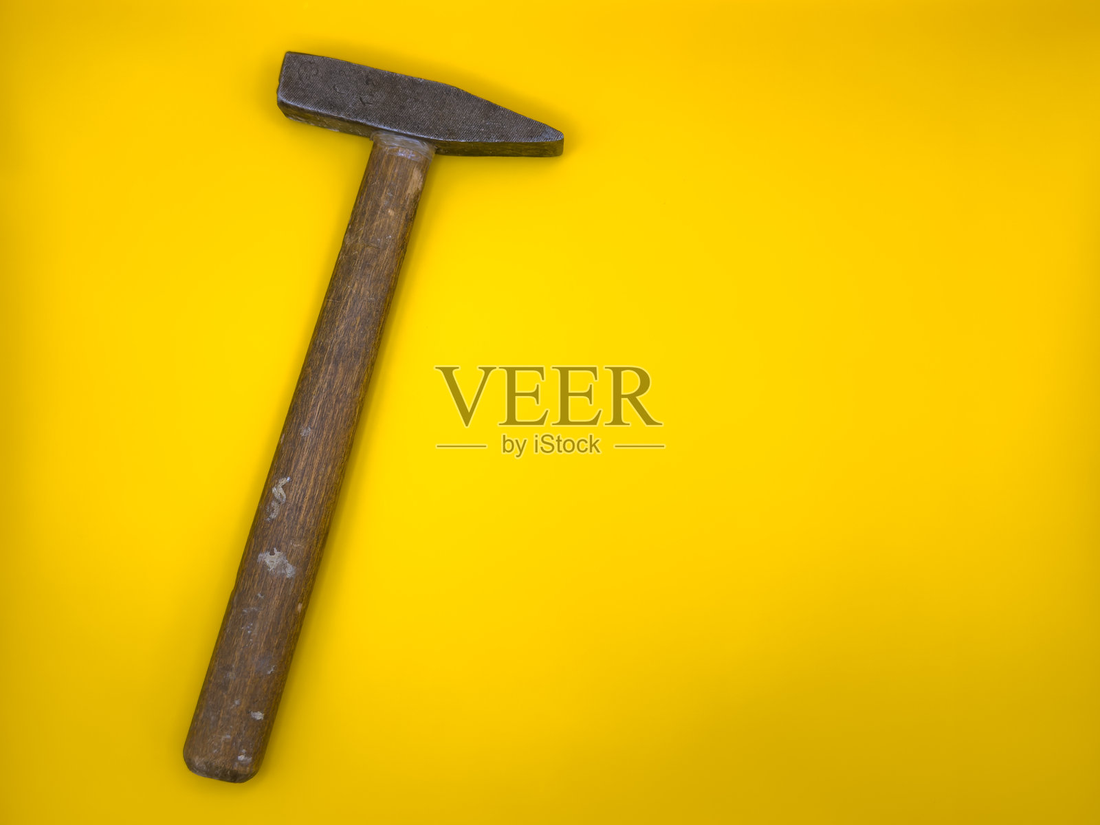 锈迹斑斑的旧锤子，木柄，背景为黄色。平铺，俯视图，留白空间。照片摄影图片