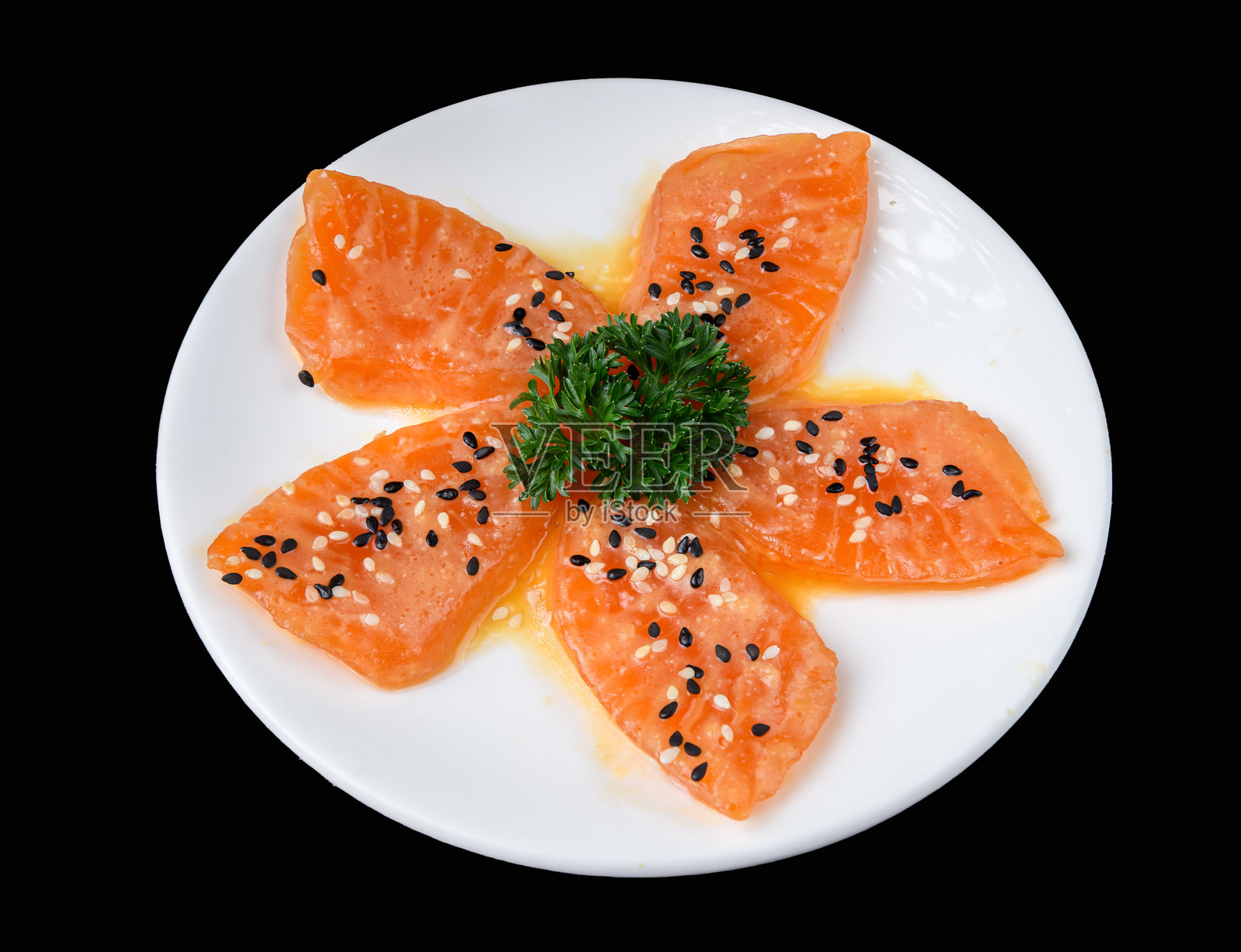 白盘上的三文鱼刺身片撒上芝麻照片摄影图片