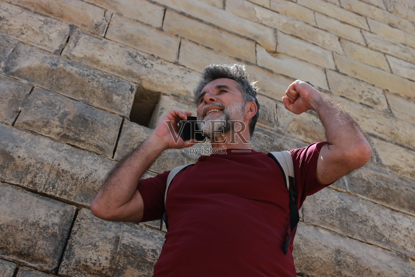 老年游客在海边使用手机照片摄影图片