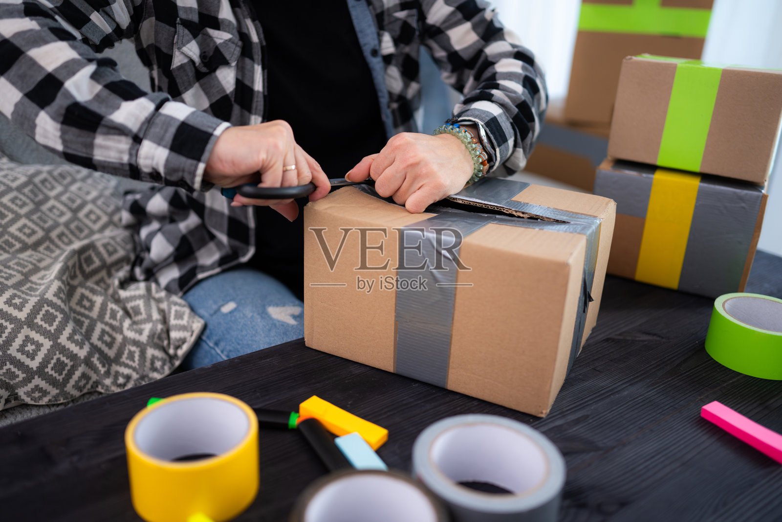 女孩拆包裹，里面是衣服照片摄影图片