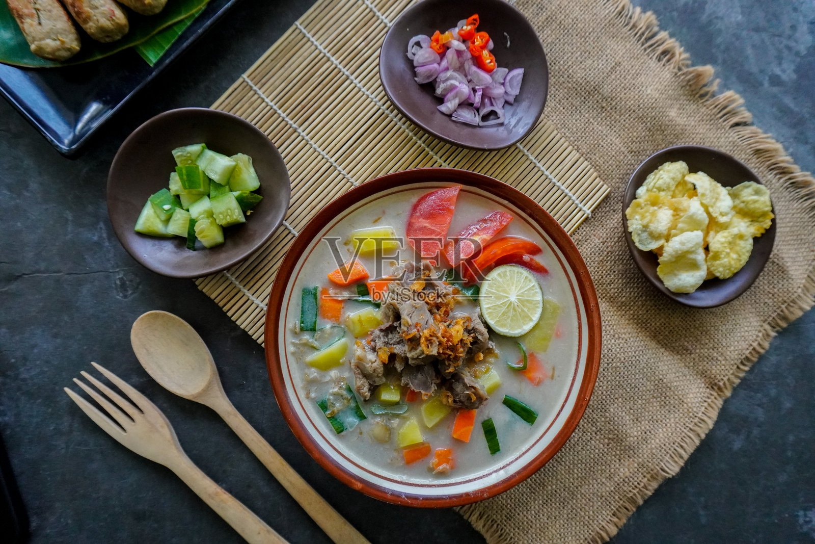 巴塔维汤是来自雅加达的传统美食，由椰奶和牛奶酱、肉类、内脏、胡萝卜、土豆、青柠和香料混合而成。照片摄影图片