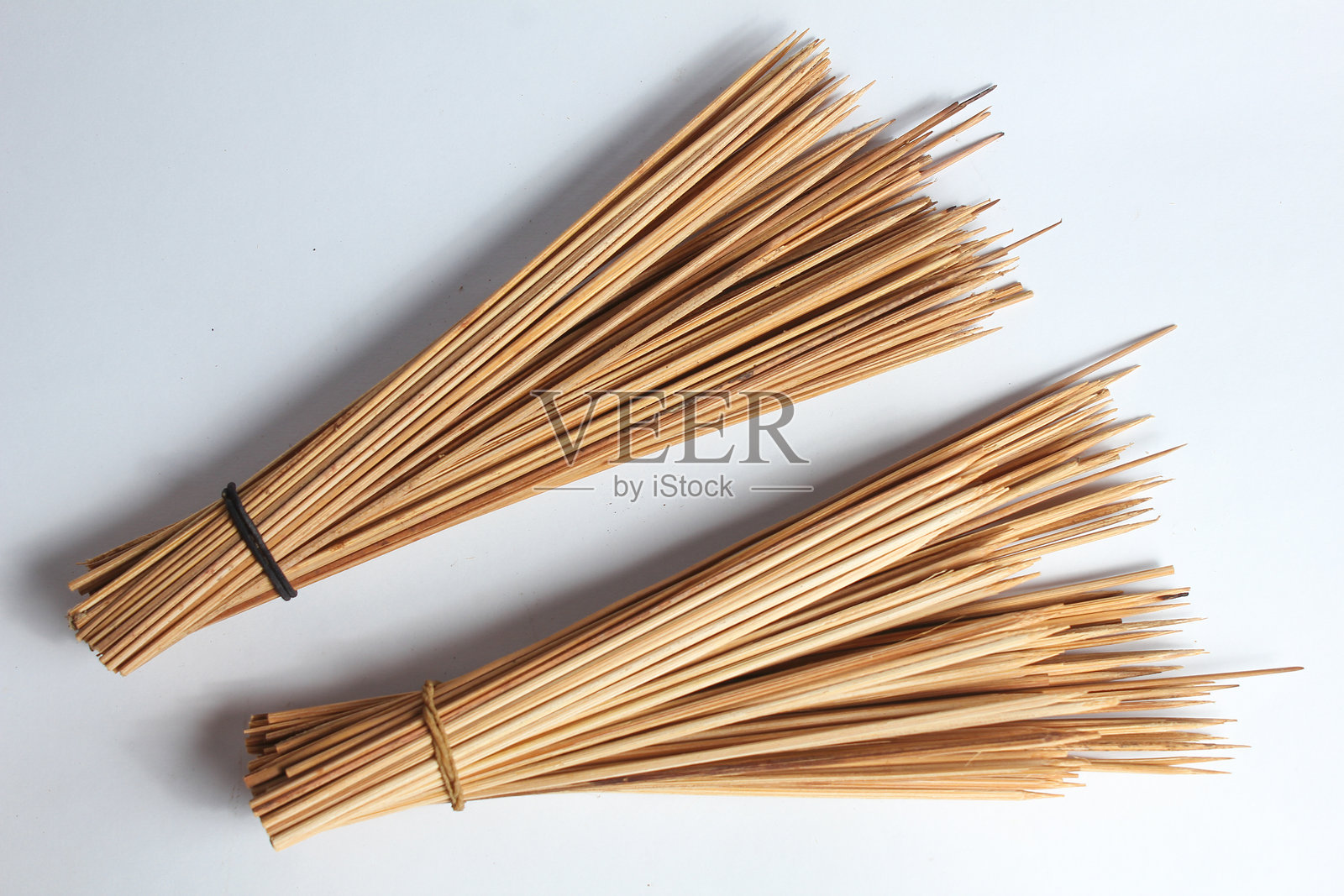 一束用橡皮筋绑在一起的串烧，背景为白色。照片摄影图片