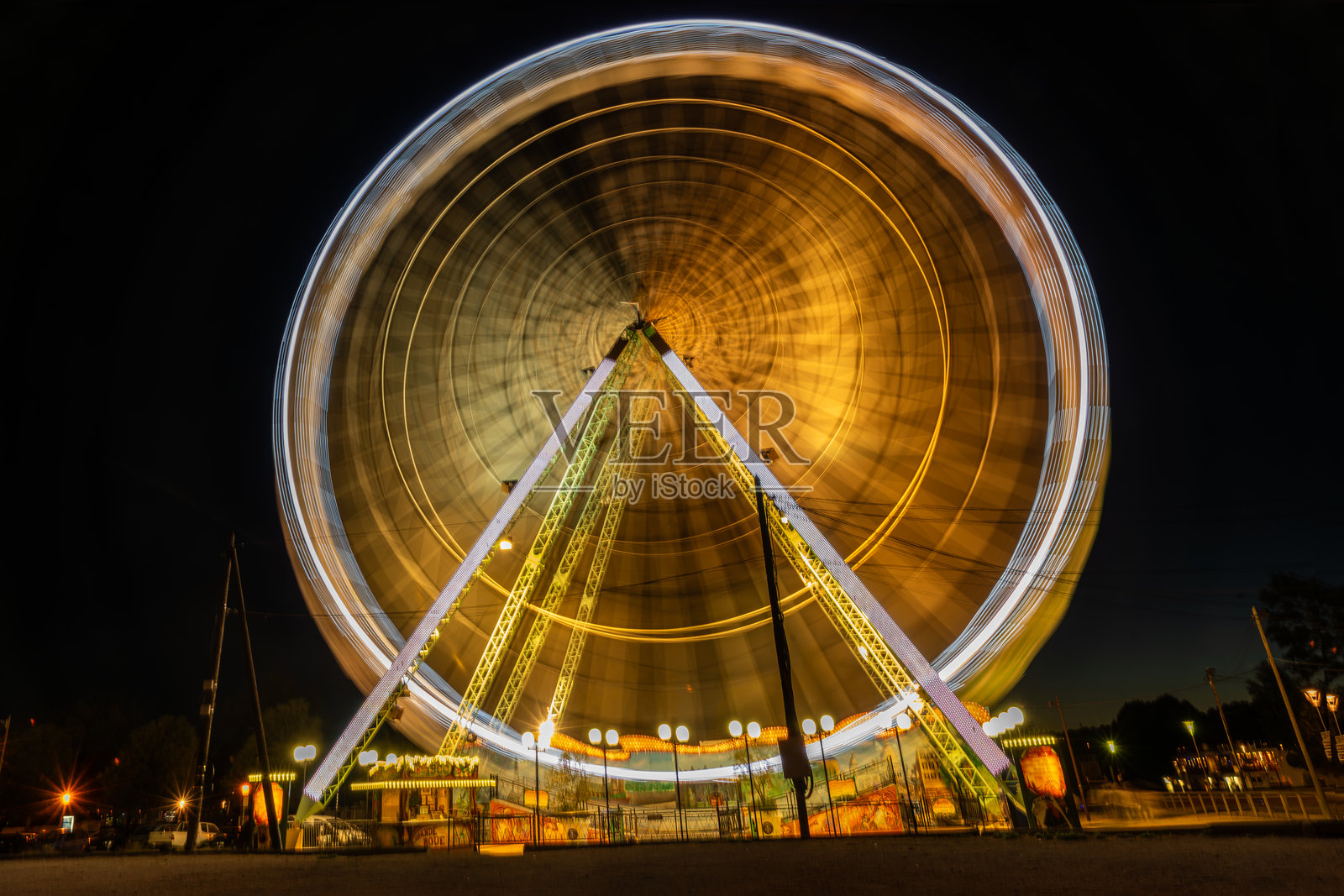在法国阿维尼翁，摩天轮璀璨旋转，绚丽的灯光在夜空中形成迷人的光带，展现出动感的活力和节日的魅力。照片摄影图片