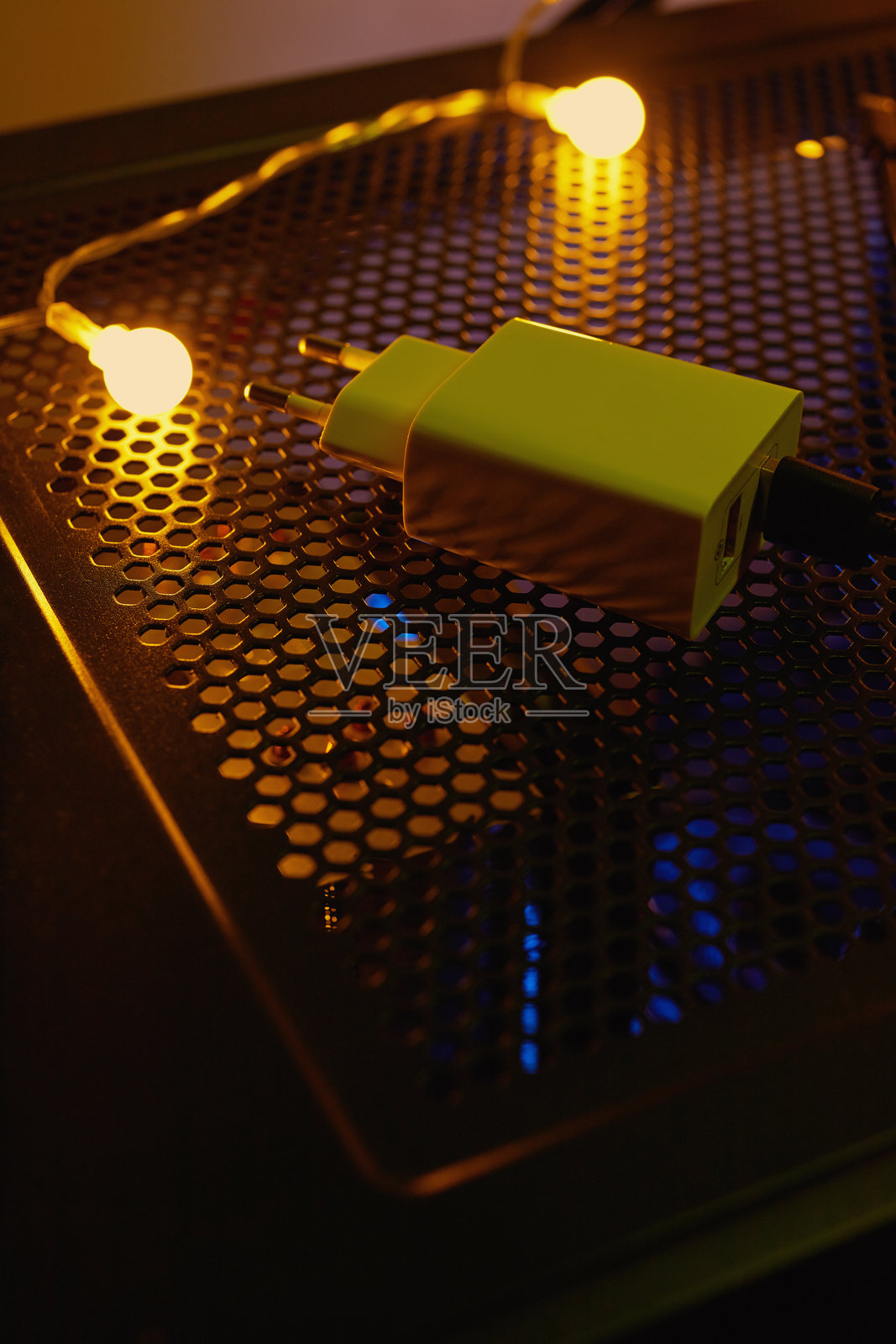 夜间科技桌上的手机充电器，周围有霓虹灯。照片摄影图片