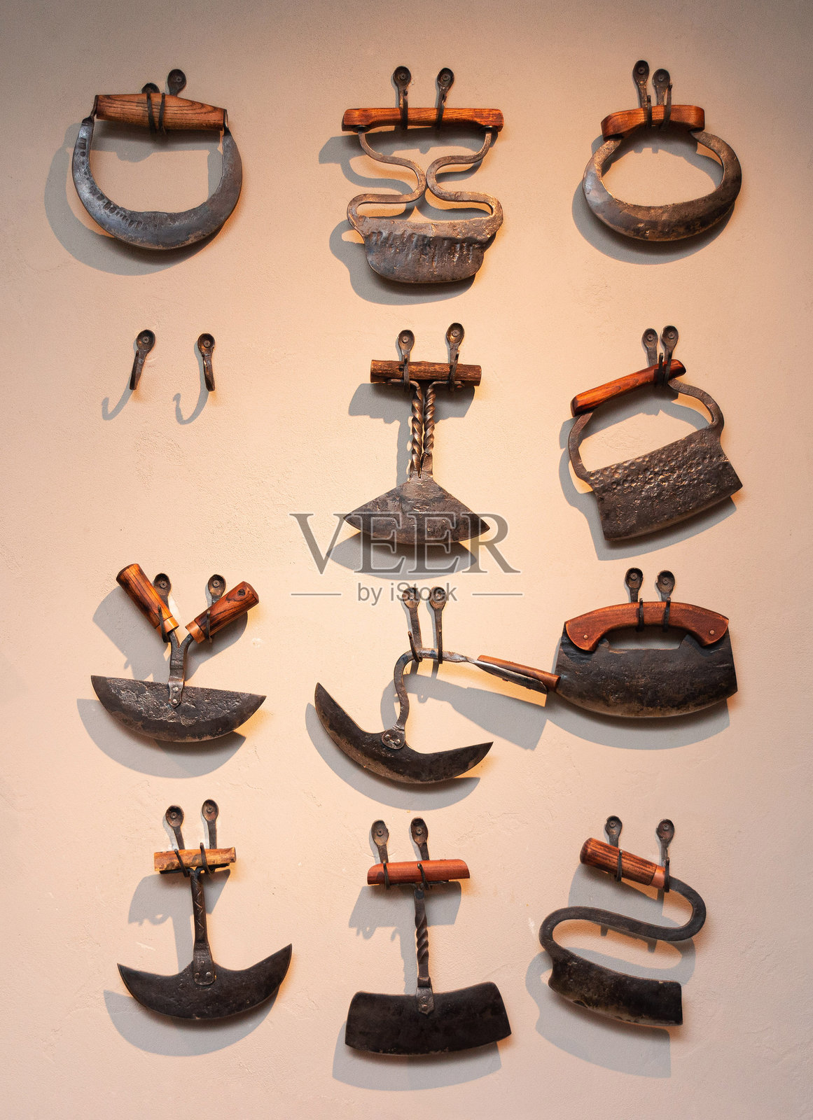 墙上展示的复古切肉刀收藏。照片摄影图片