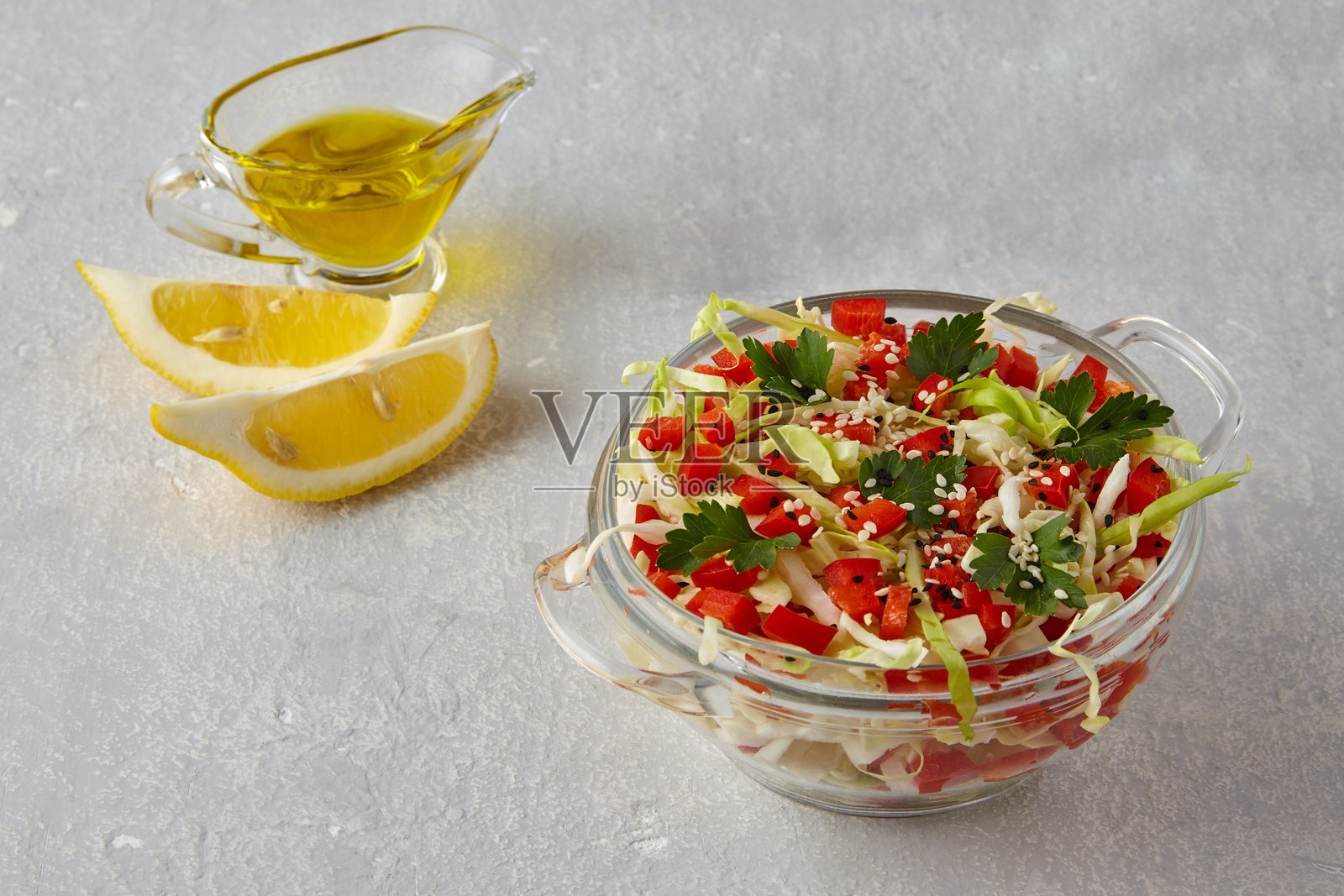 卷心菜沙拉配甜椒和香菜，撒上芝麻，淋上橄榄油和柠檬汁照片摄影图片