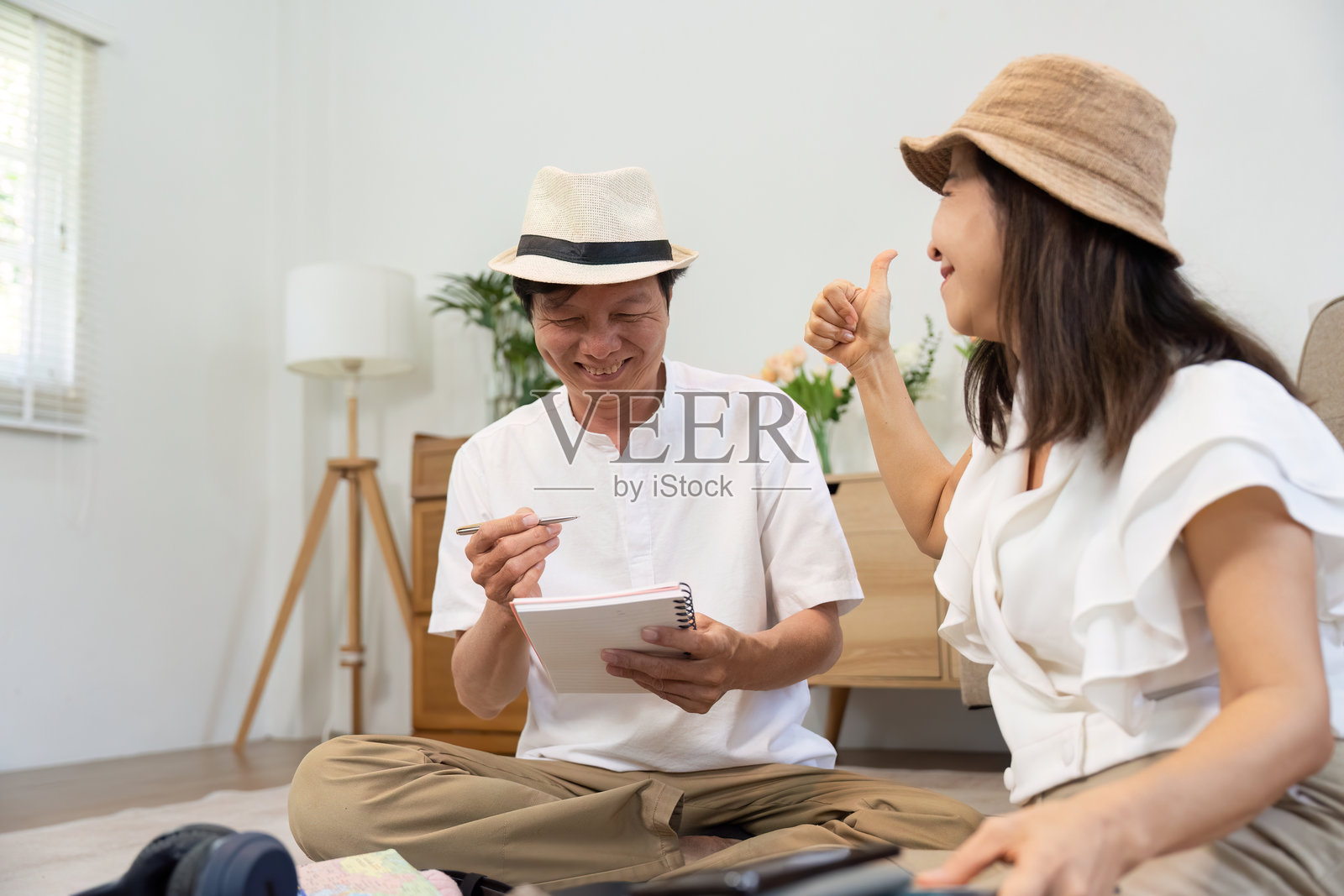 创意票务与欢乐时刻。一对情侣在愉快的旅行准备中，充满了欢声笑语和兴奋。照片摄影图片