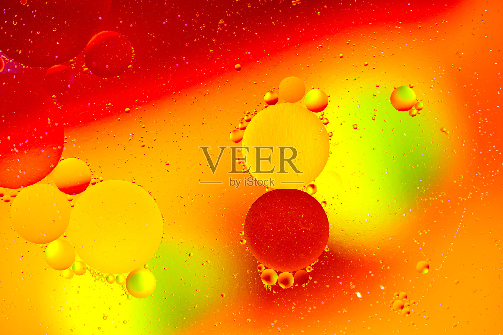 五彩斑斓的油滴漂浮在水面上。抽象色彩的水泡背景。节日灯光背景。水面上的油滴。照片摄影图片