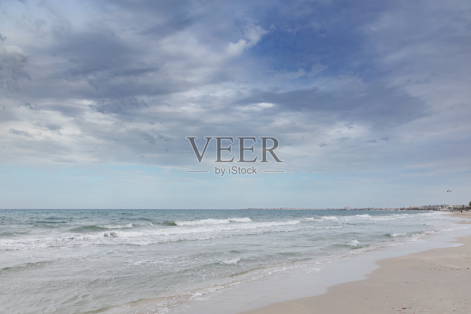 海滩场景，波浪与多云的天空照片摄影图片