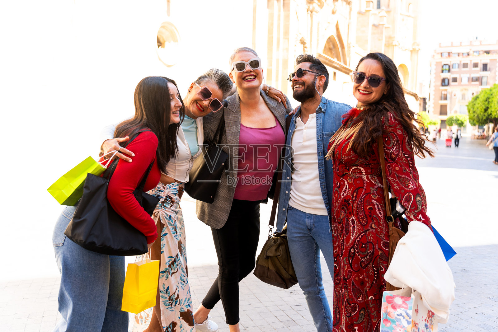 快乐的朋友们在市中心购物后互相拥抱照片摄影图片