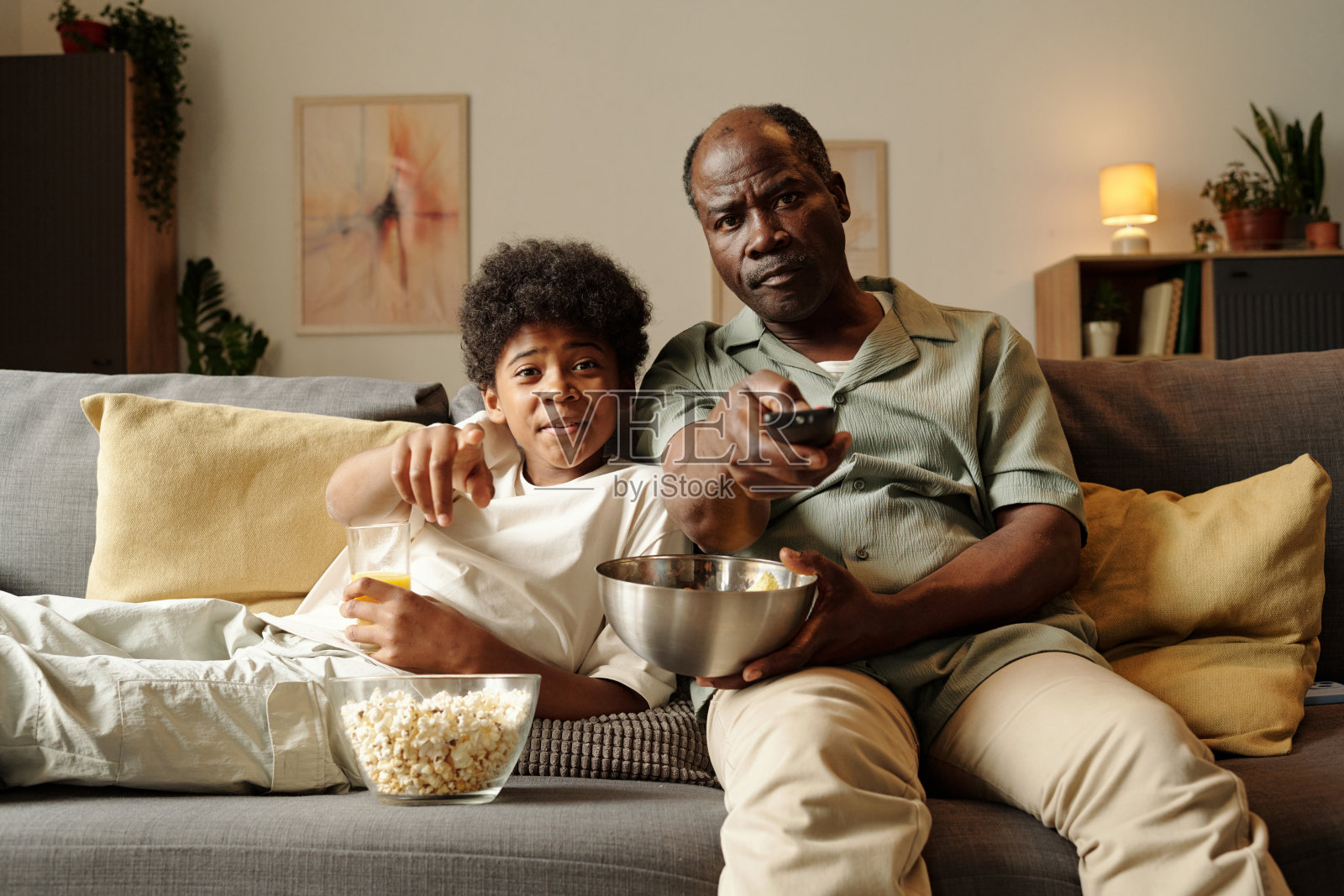 父亲和孩子在沙发上看电视照片摄影图片