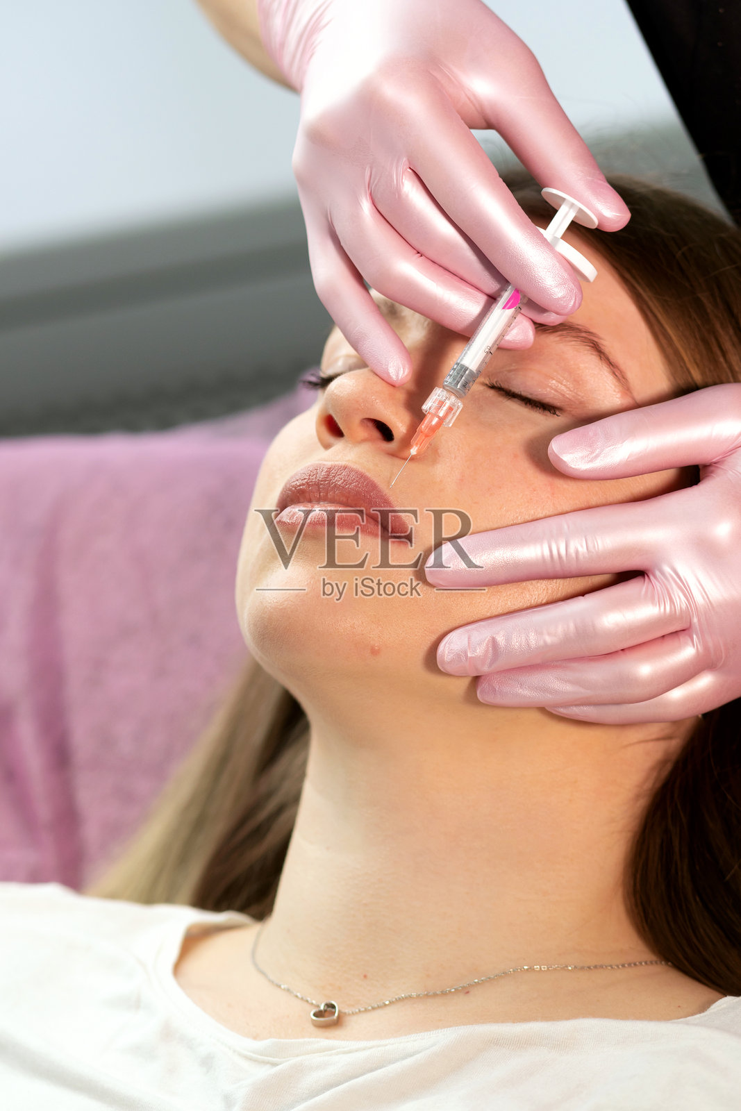 美容师精准注射透明质酸唇部填充剂照片摄影图片