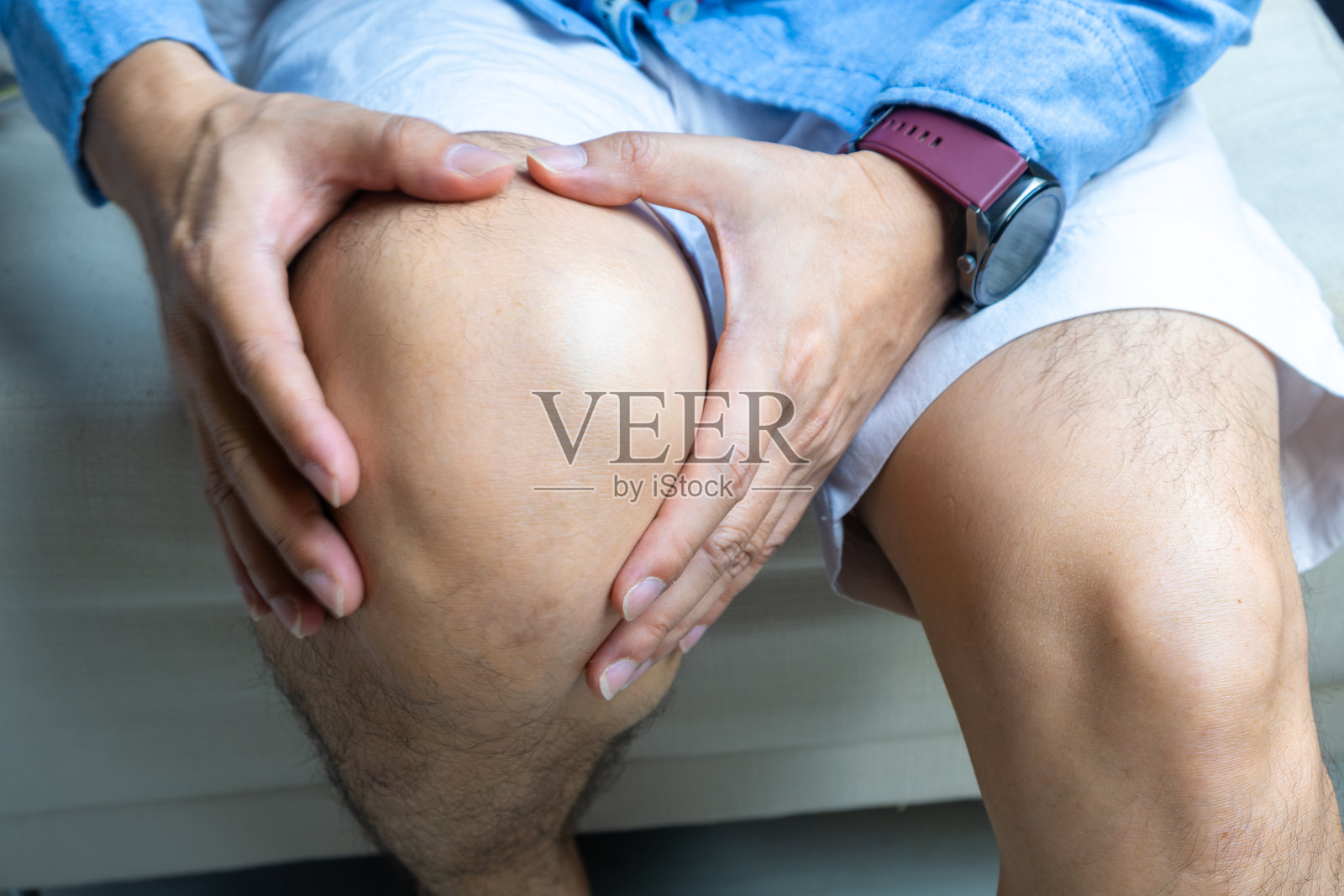 膝盖疼痛的男人，他双手放在膝盖上，疼痛点来自骨关节炎和骨病，医学概念和治疗。照片摄影图片