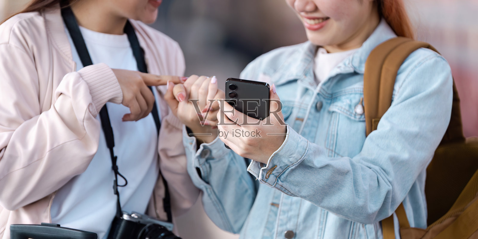 旅行计划与快乐时光。朋友们在火车站查看手机时分享兴奋。照片摄影图片