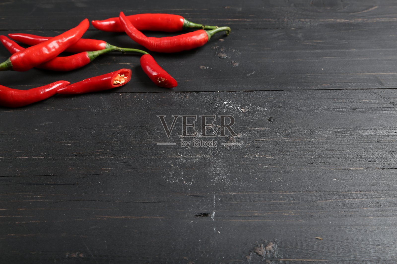 新鲜红辣椒放在深色木质背景上照片摄影图片