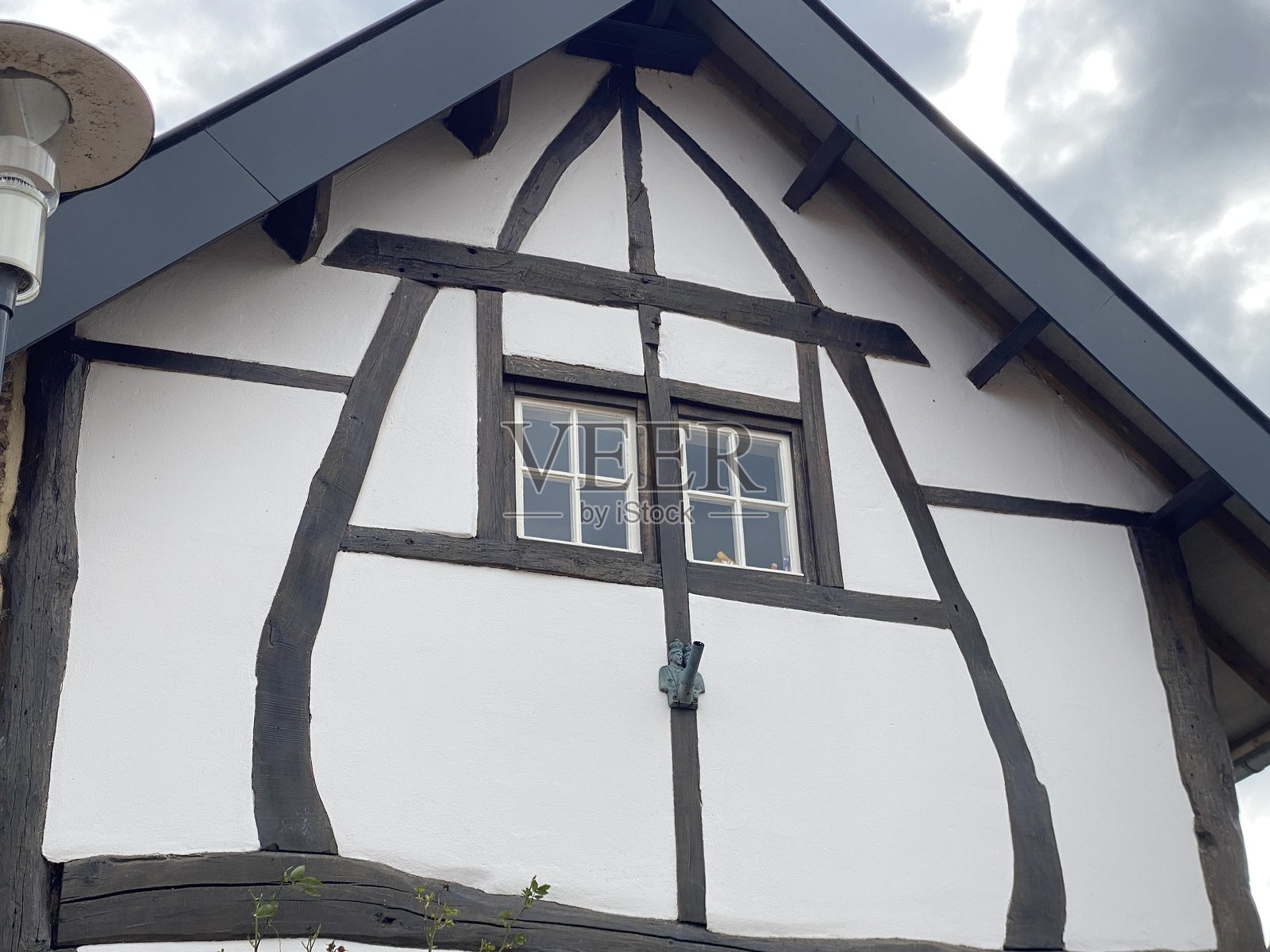 历史农舍中的半木框架的一部分。照片摄影图片