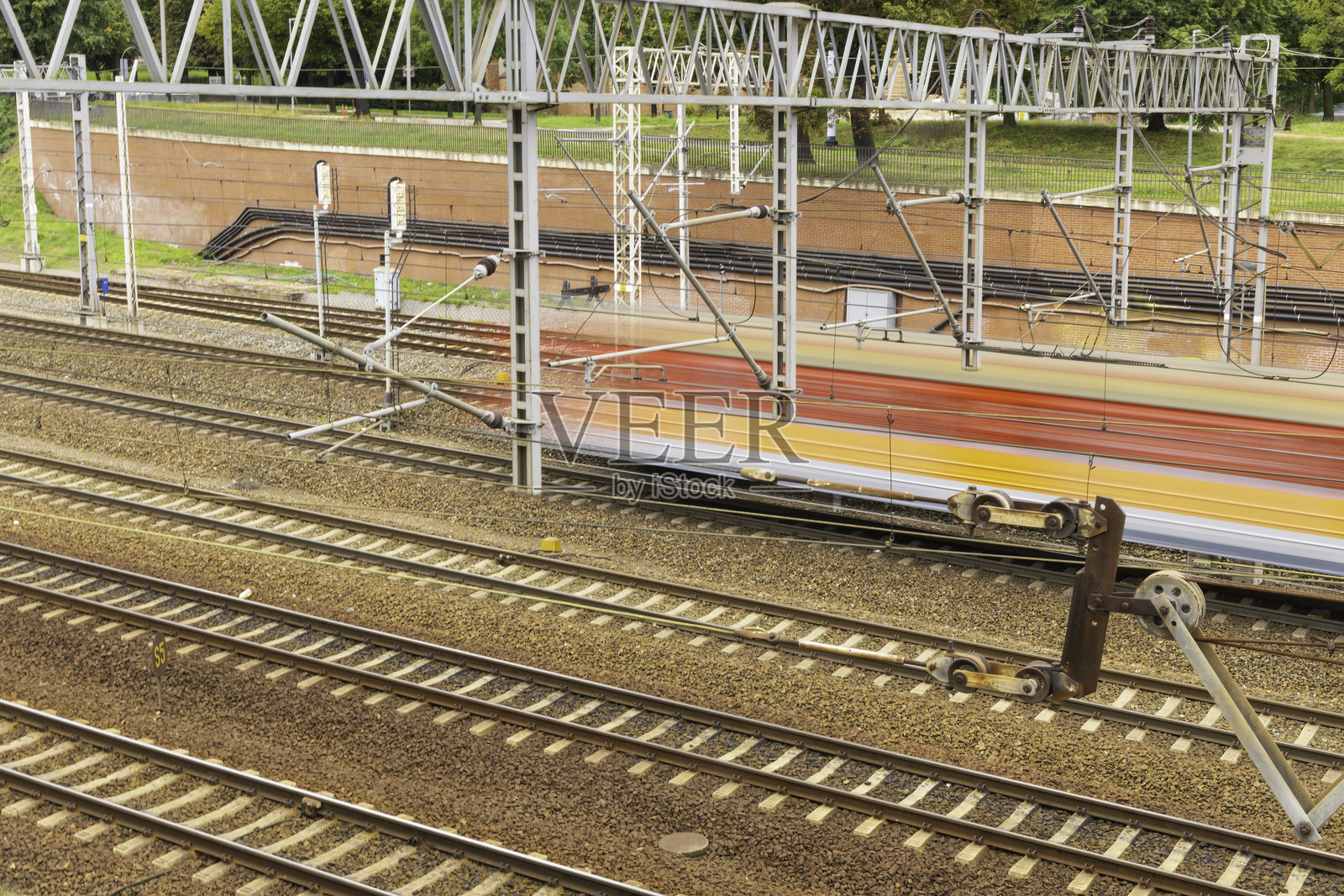 色彩斑斓的火车在城市区域的铁路上行驶，背景是晴朗的天空。照片摄影图片