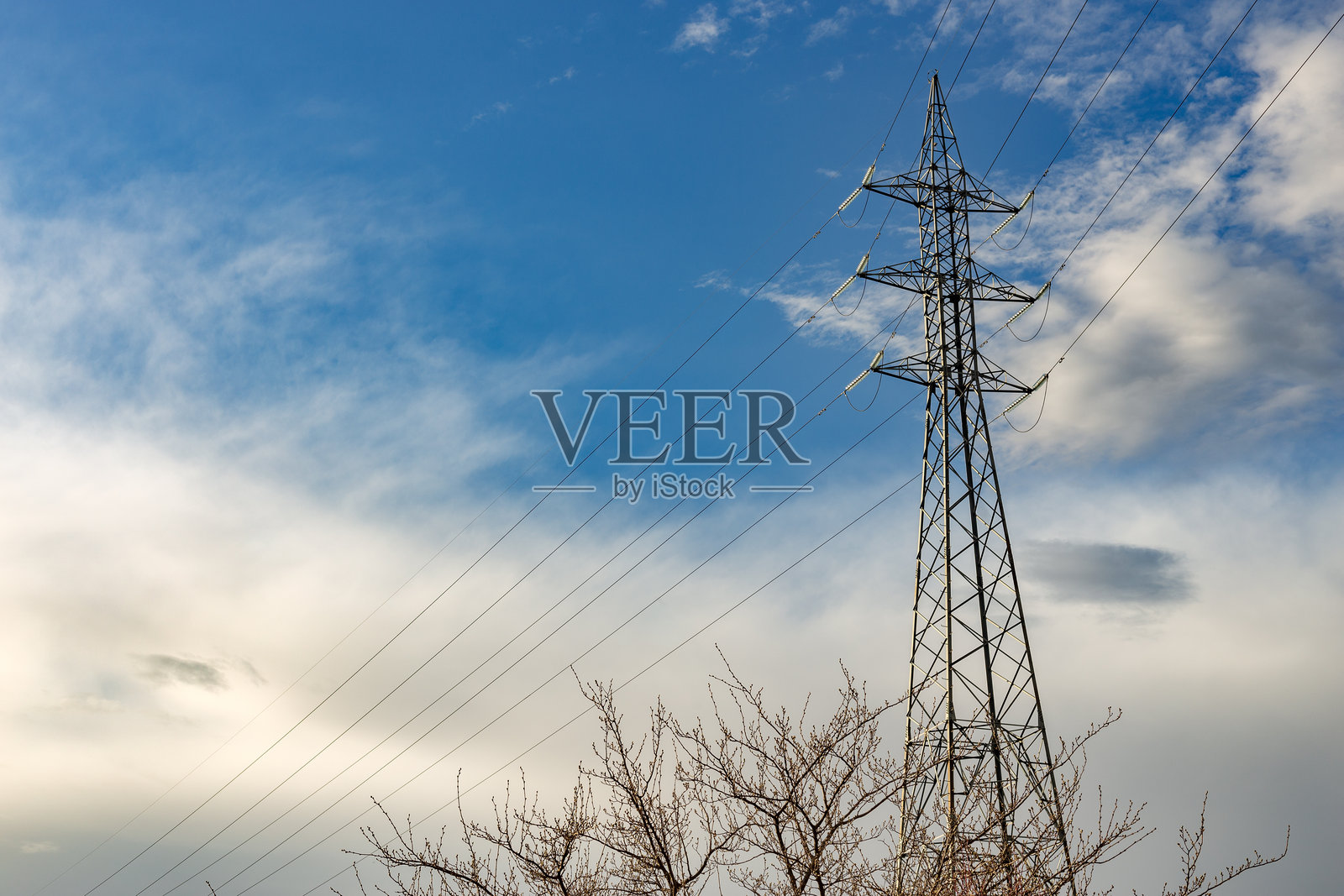 高耸的电力塔矗立在多云的天空下照片摄影图片