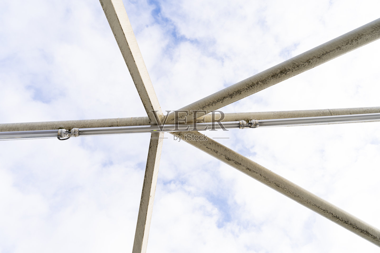 金属桁架结构与多云天空下的荧光灯照片摄影图片