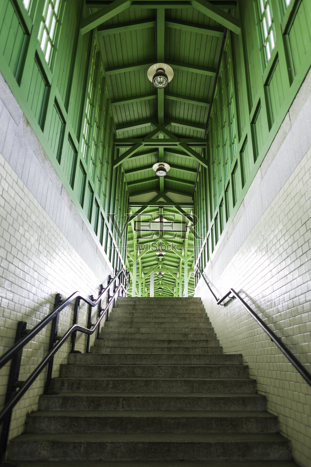 通往城市白天的精美设计地铁站的台阶，站内有绿色木质建筑。照片摄影图片