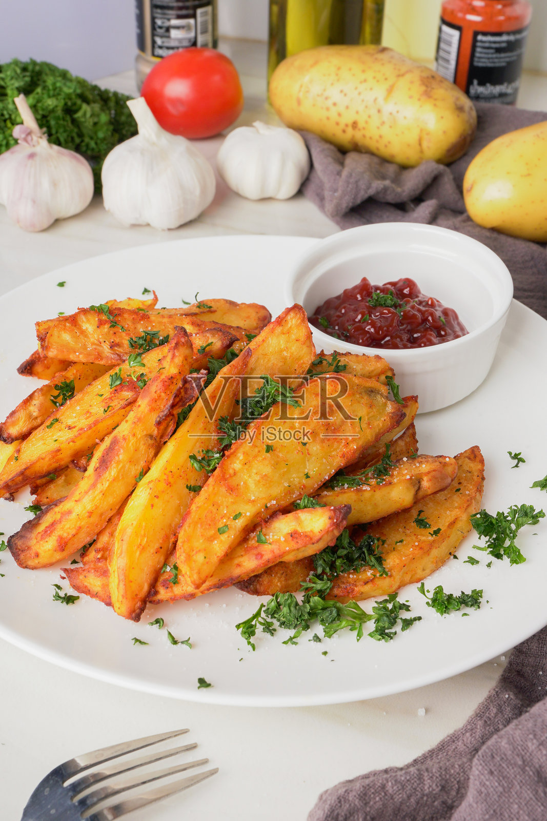 烤土豆，撒上红椒粉和大蒜， topped with 新鲜的香菜和浓郁的番茄酱，这是一道令人无法抗拒的自制美食，刚出炉时最为美味。照片摄影图片