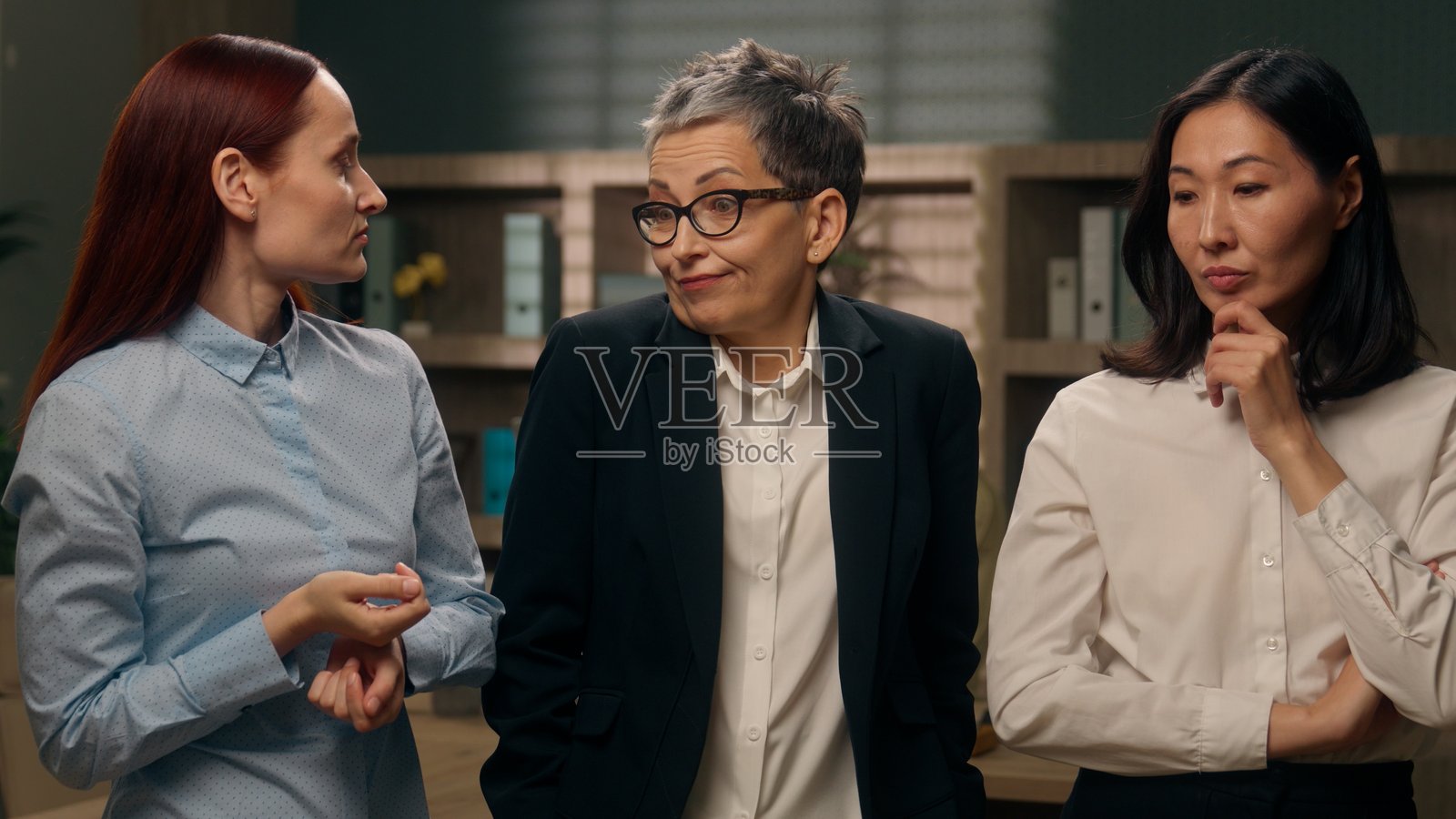 多样化的思考女性，困惑地思考寻找答案，白人女士耸耸肩表示不确定，成年女性领导者寻找解决方案，亚洲韩国女性举起手指表示想法，商业女性在办公室。照片摄影图片