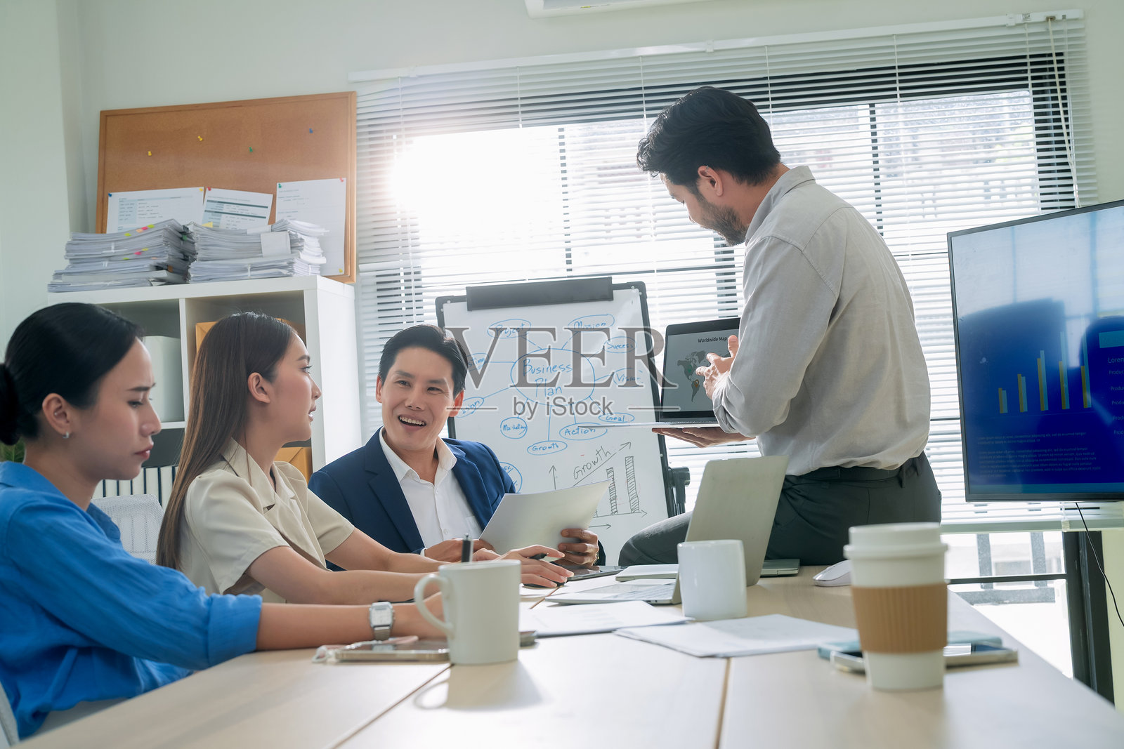 同事们在办公室会议室开会，亚洲年轻商人带领团队讨论他们的项目，女商人和男商人正在主持会议。照片摄影图片