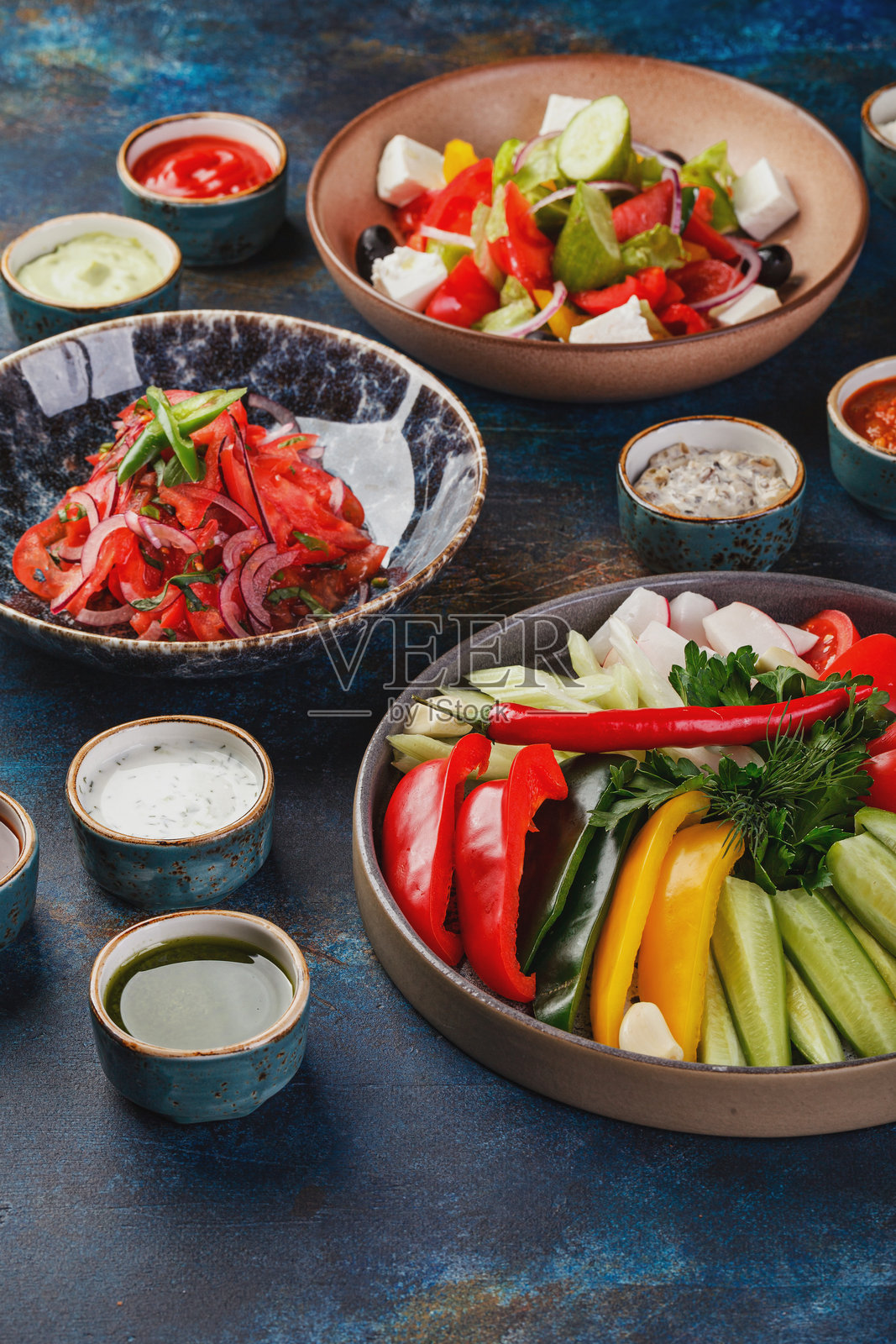 蔬菜、辣椒、西红柿和绿叶菜的菜肴，配有各种蔬菜沙拉和多种酱汁的盘子照片摄影图片