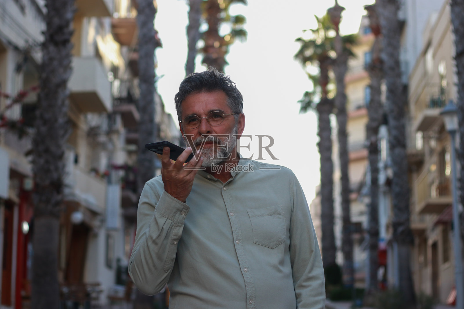 街头的老年人和棕榈树照片摄影图片