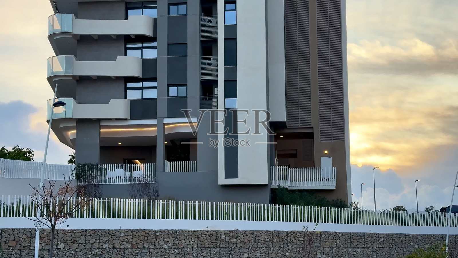 现代公寓大楼，壮观的日落景色令人陶醉照片摄影图片