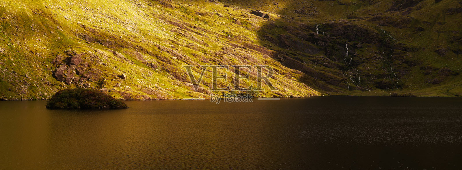 宁静的风景展示了卡利湖，平静的湖水映照出山丘的生机盎然，展现了日落时分大自然的美丽。非常适合宁静的户外探险。照片摄影图片