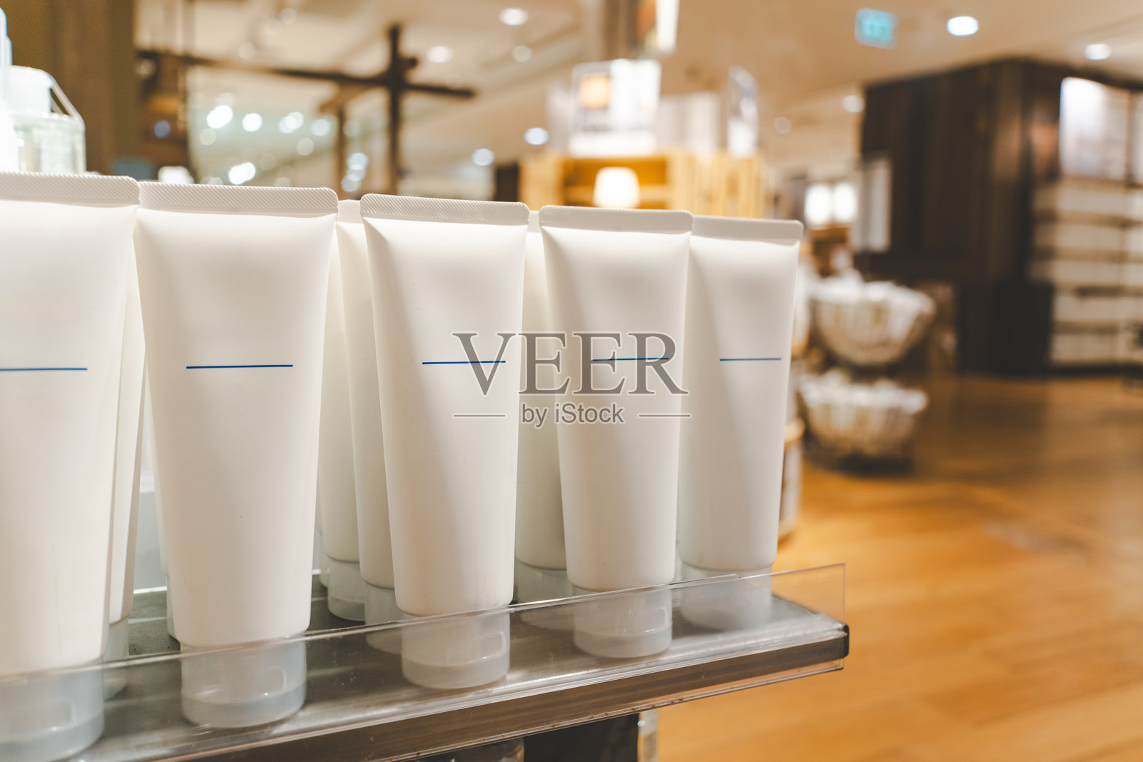 美容店货架上的空化妆品管。照片摄影图片