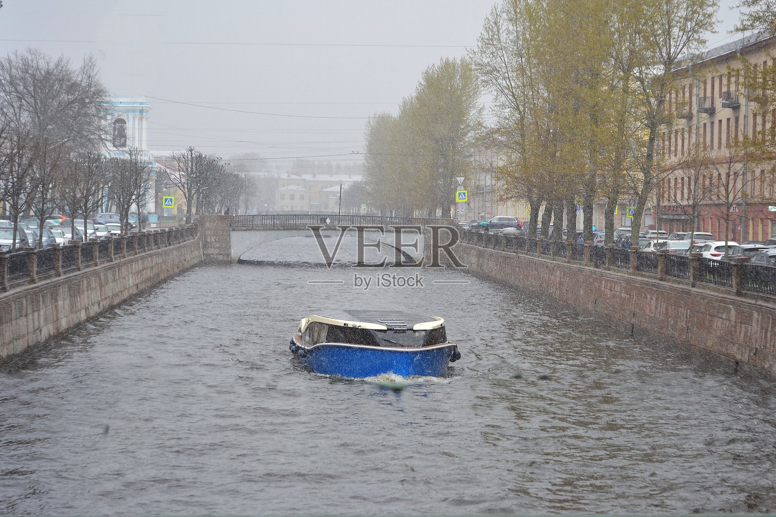 一艘船在降雪中穿过运河照片摄影图片