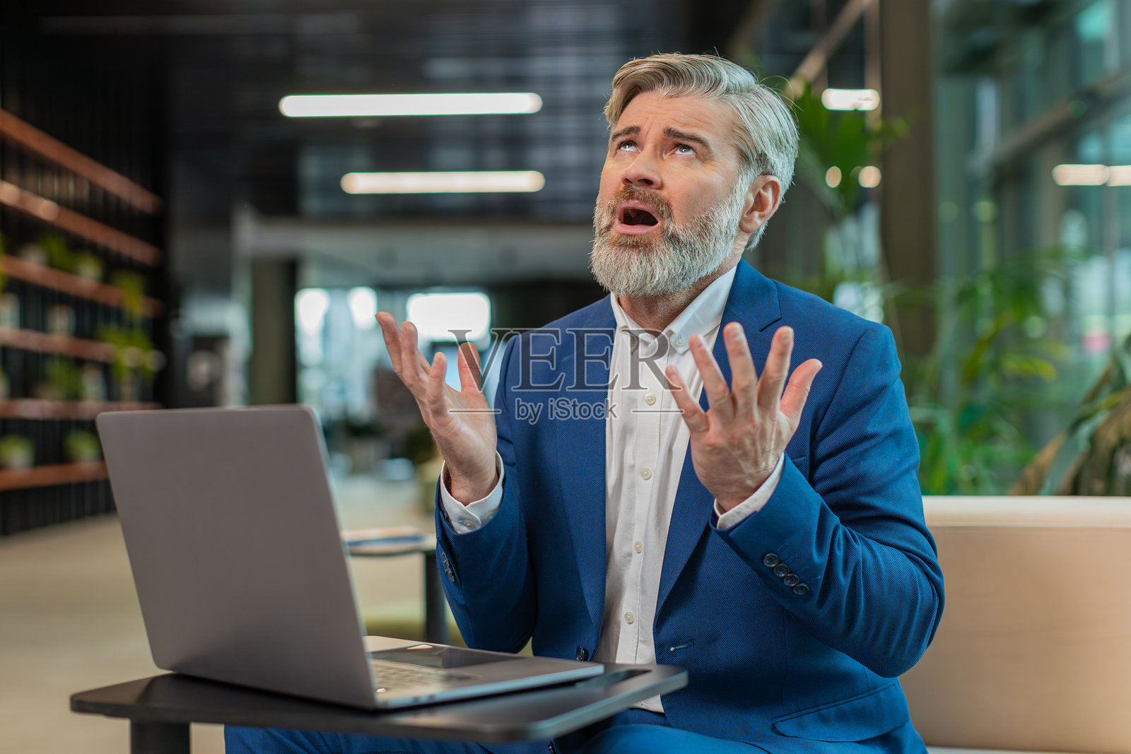 感到担忧的商人因财务问题而心烦意乱，坐在现代办公室大堂里度过糟糕的一天。照片摄影图片