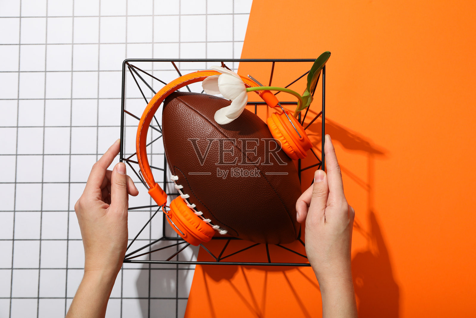 橙色背景上的带花橄榄球。照片摄影图片