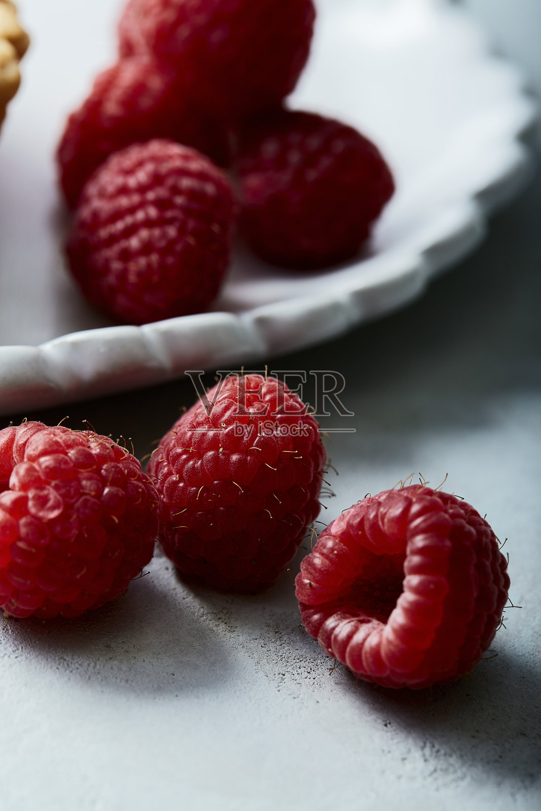 白色波浪边盘上的巧克力挞配新鲜覆盆子照片摄影图片