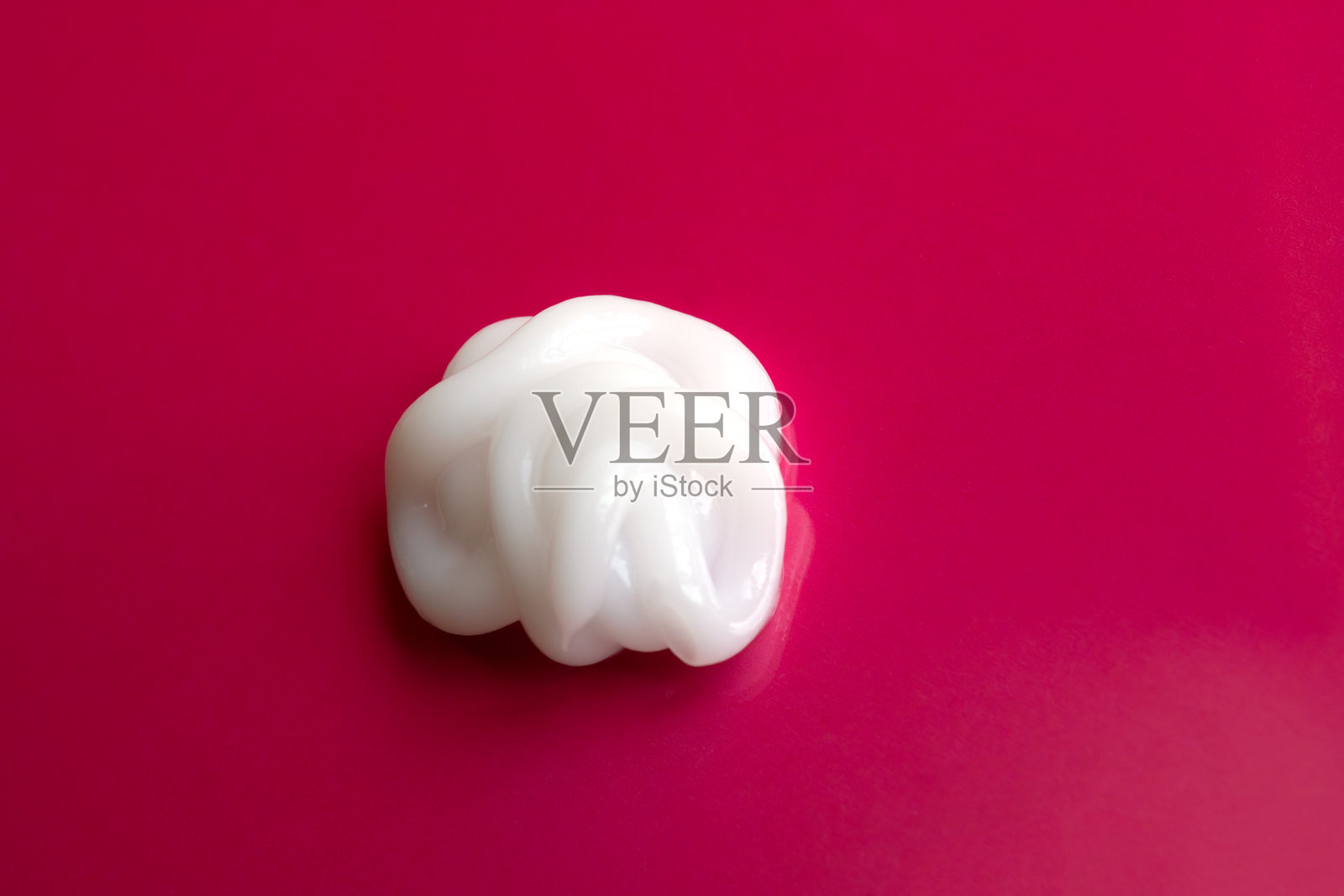 红色背景上的化妆霜涂抹痕迹照片摄影图片