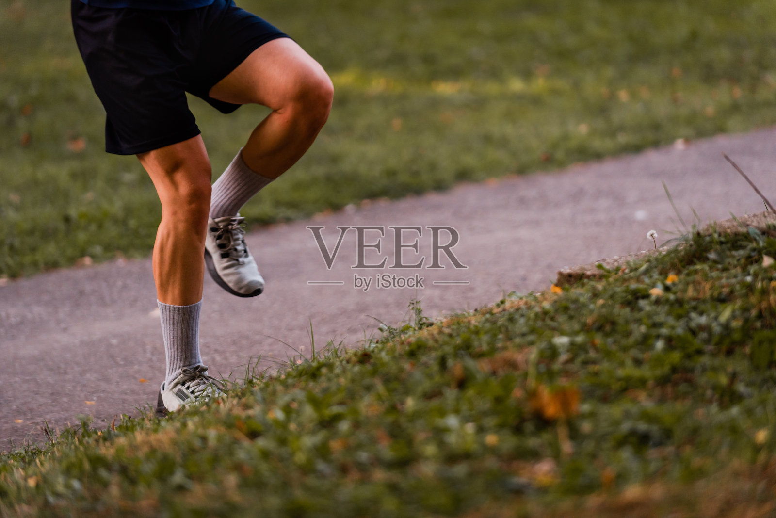 裁剪的运动男士在越野跑道上奔跑的图像。照片摄影图片