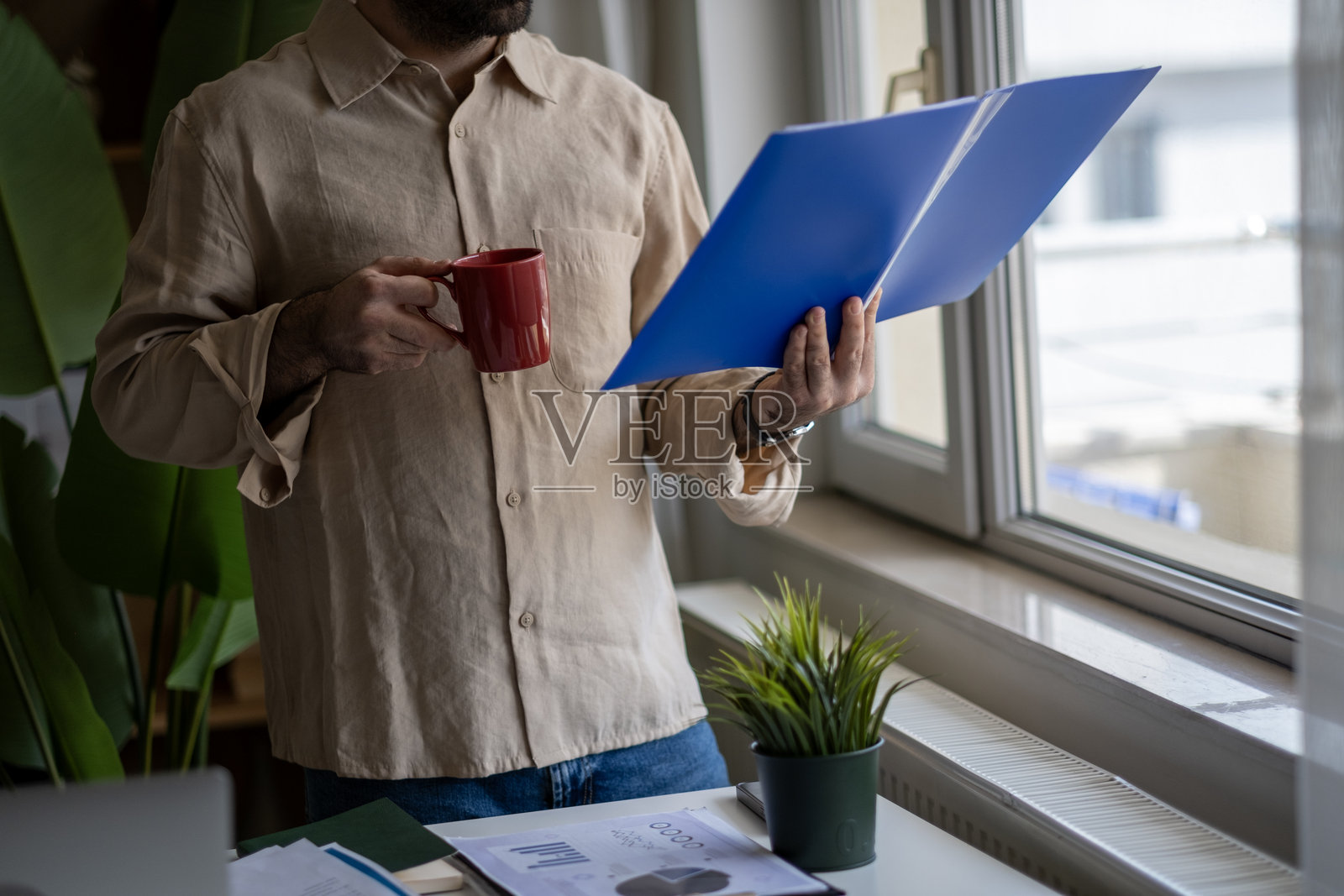 成熟的商人站在桌子旁，分析商业报告照片摄影图片
