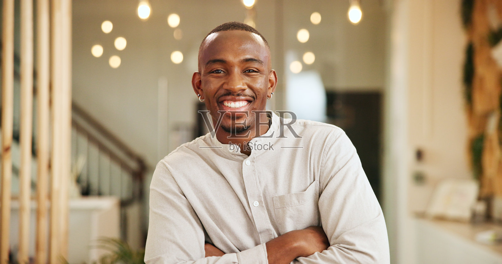 快乐的黑人男性在酒店大堂交叉双臂准备办理入住，享受假期或度假。微笑，自信的非洲男性在周末旅行的住宿中。照片摄影图片