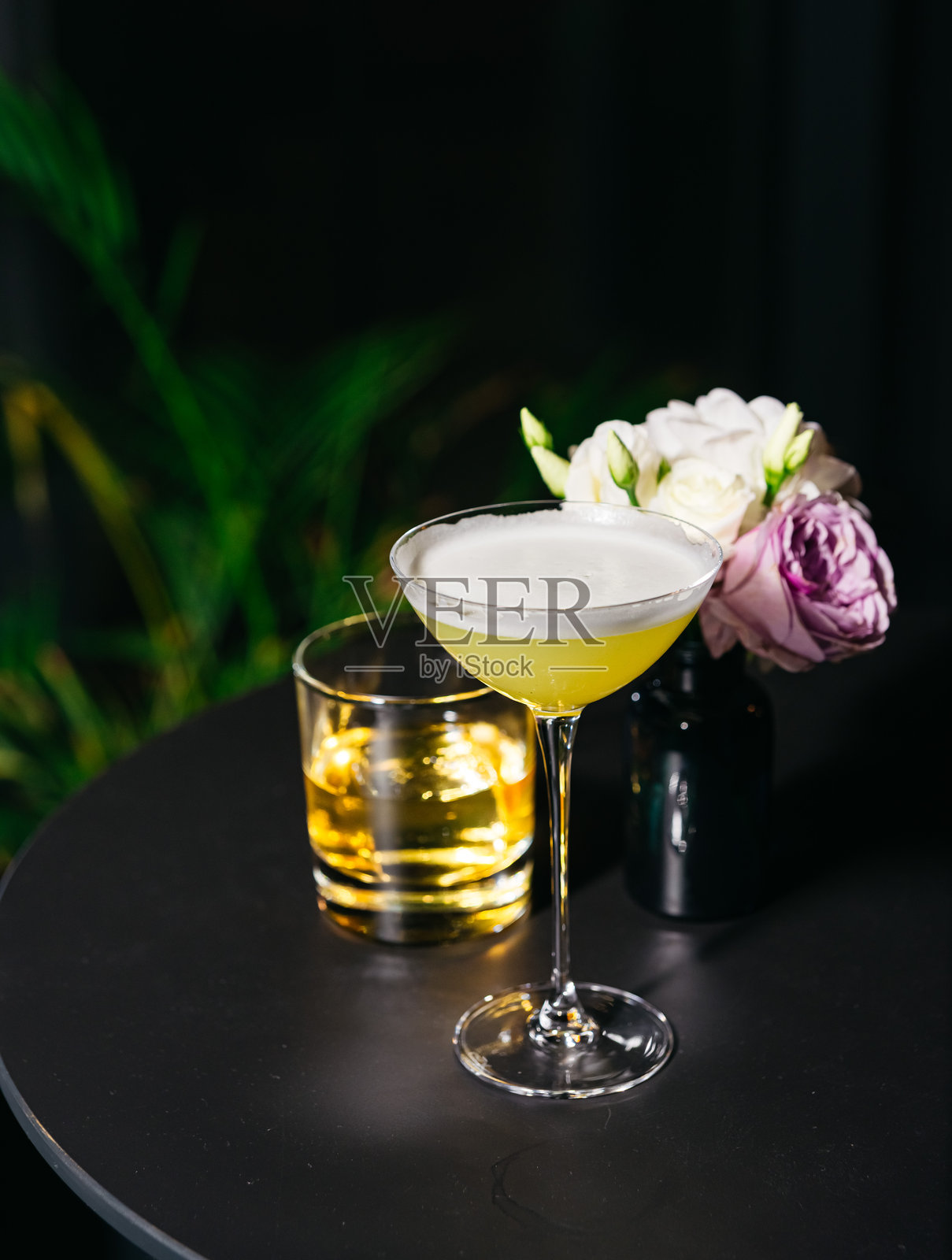 时尚的黄色鸡尾酒配有花卉装饰。照片摄影图片