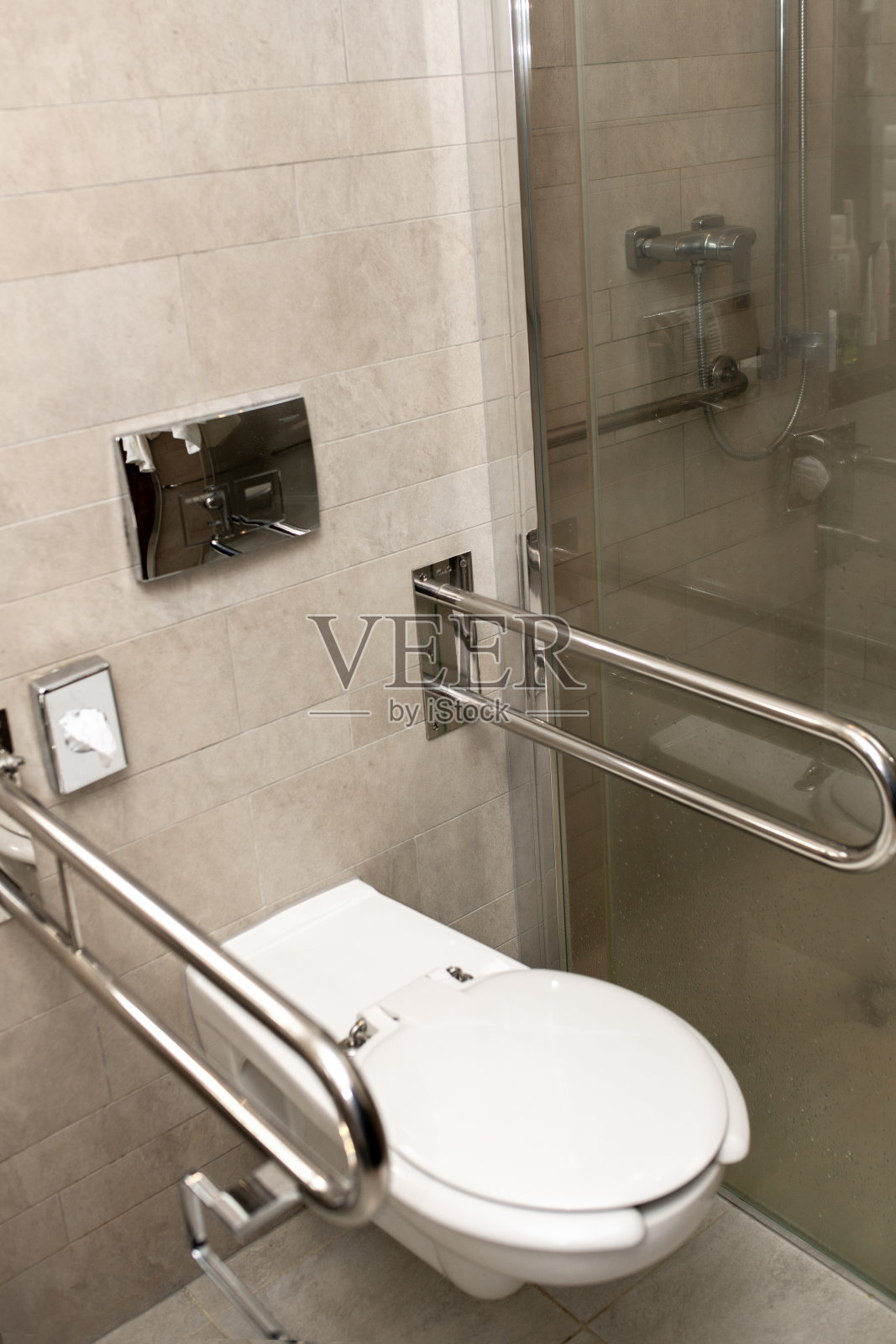 现代酒店浴室内配有安全扶手的无障碍厕所照片摄影图片